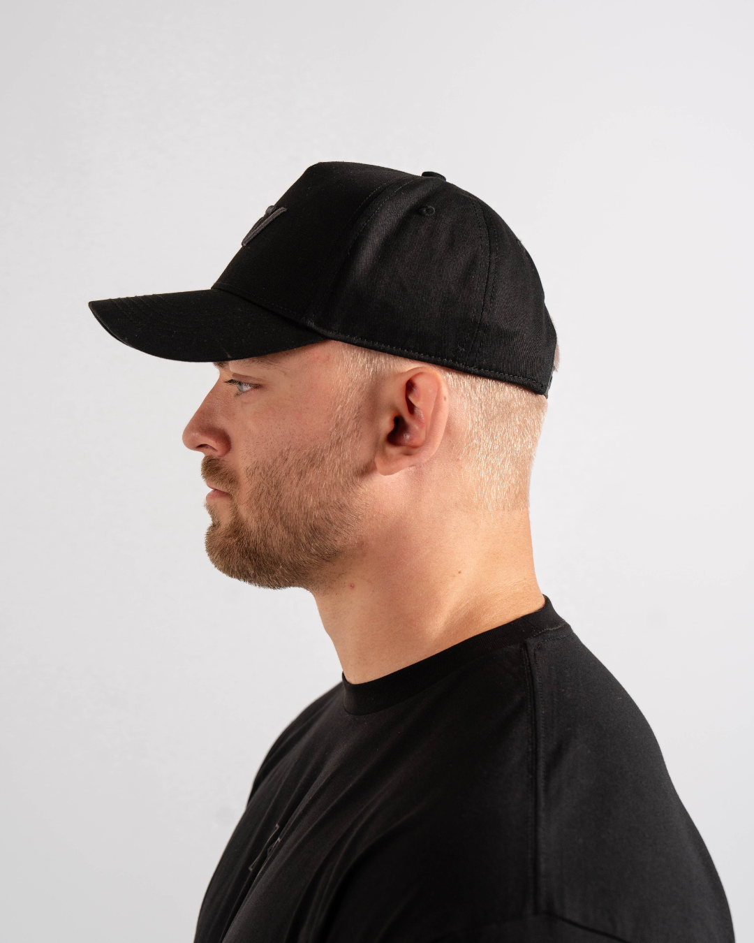 Side profile of Shadow Stone A7 snapback hat showcasing flat brim and clean tonal finish.