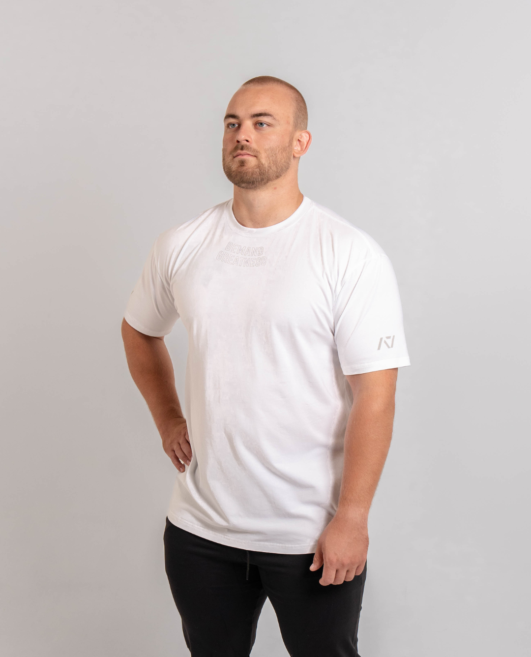 A man wearing a white t-shirt with the text 'Demand Greatness' on the upper chest and the A7 logo on the upper back and sleeves.
