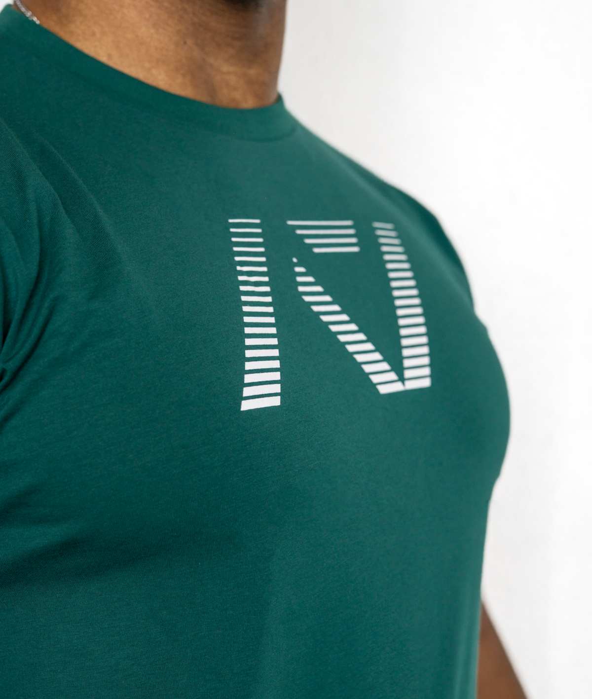Green t-shirt with a logo worn by a person on a white background
