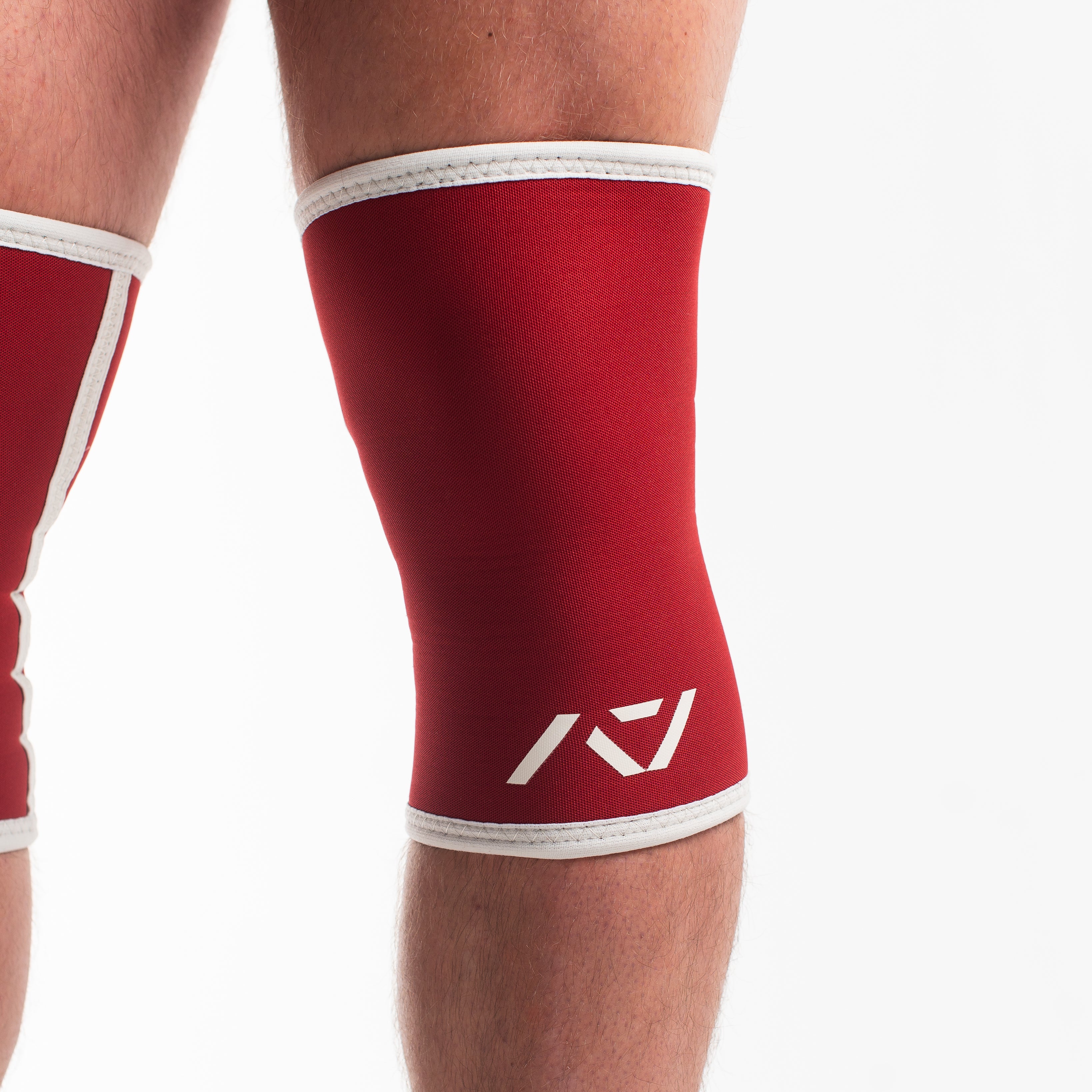 Red knee sleeve with white logo on a plain background