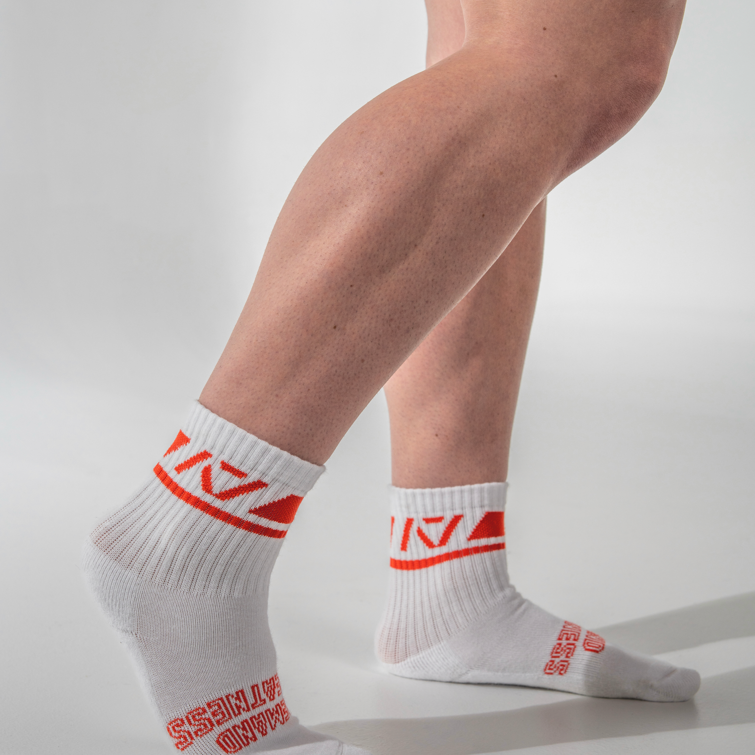 White socks with red text worn by a person on a light gray background