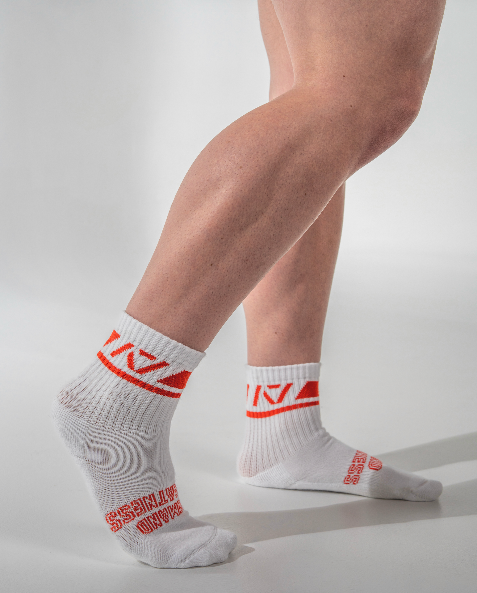 White socks with red text worn by a person on a light gray background