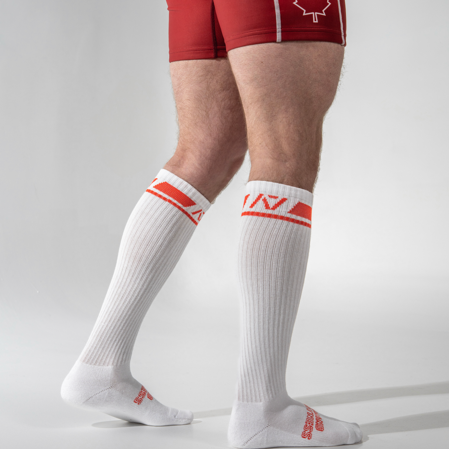 White socks with red accents worn by a person on a gray background