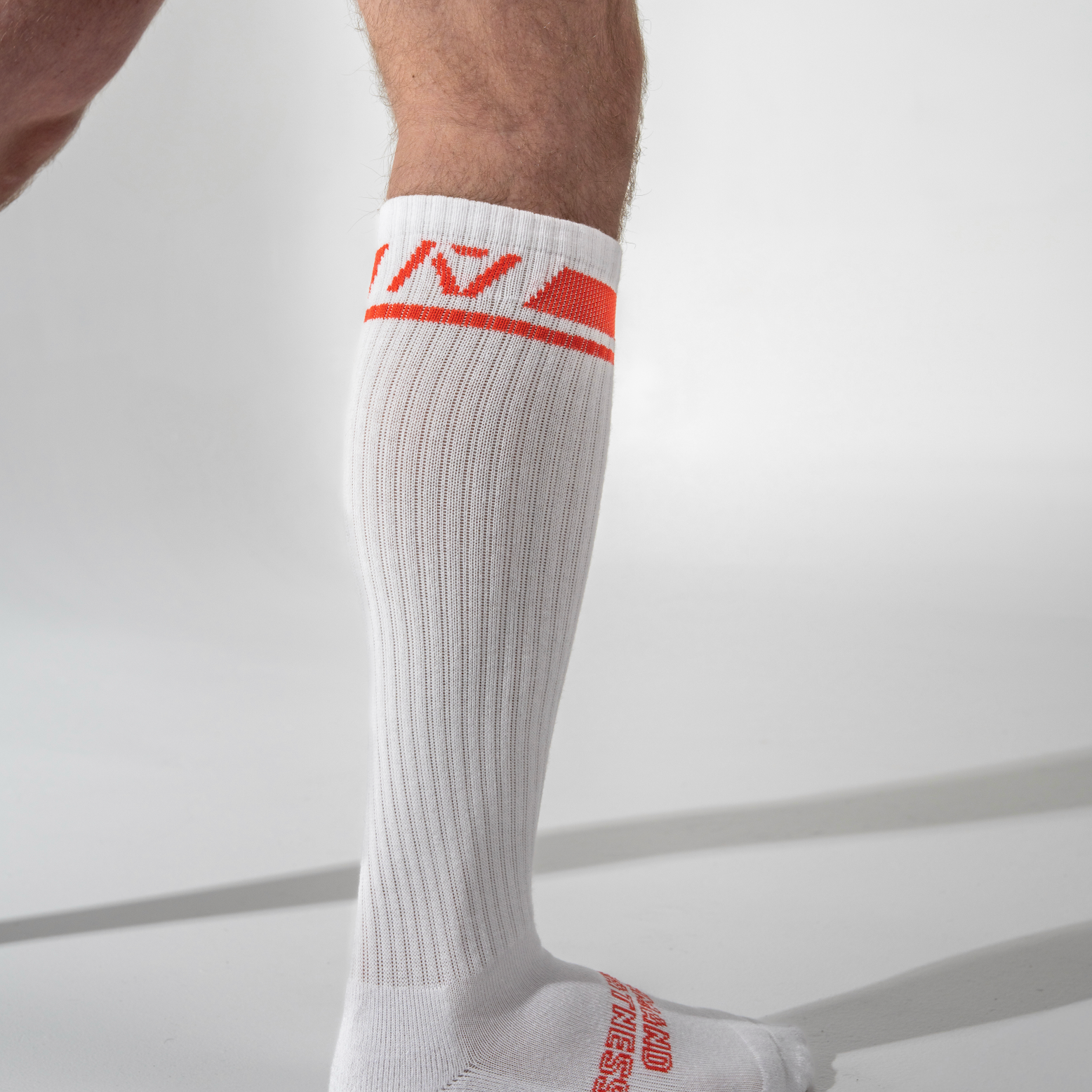 White knee-high sock with red logo and text on a light gray background