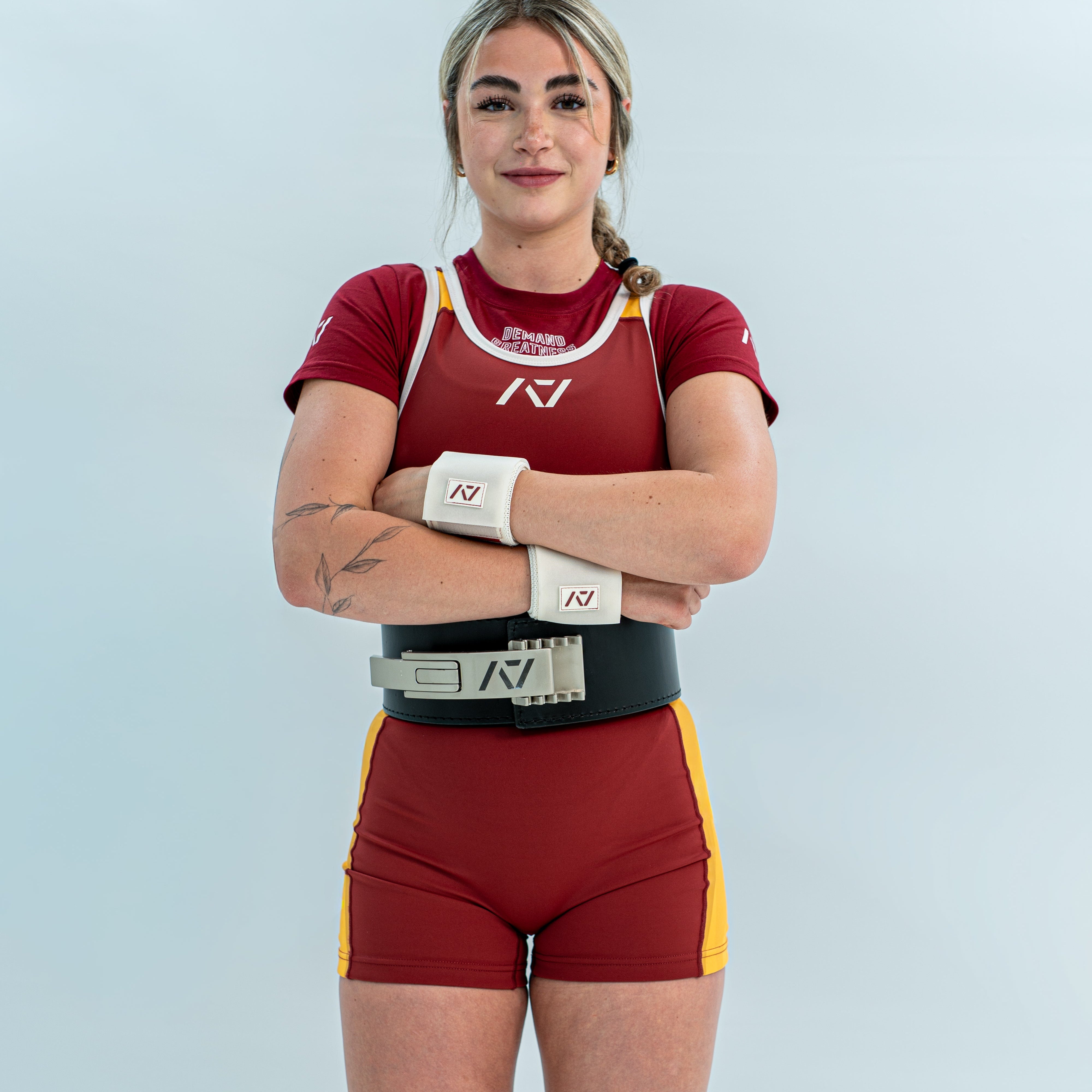 Female wearing a red and yellow rausch singlet with a white background