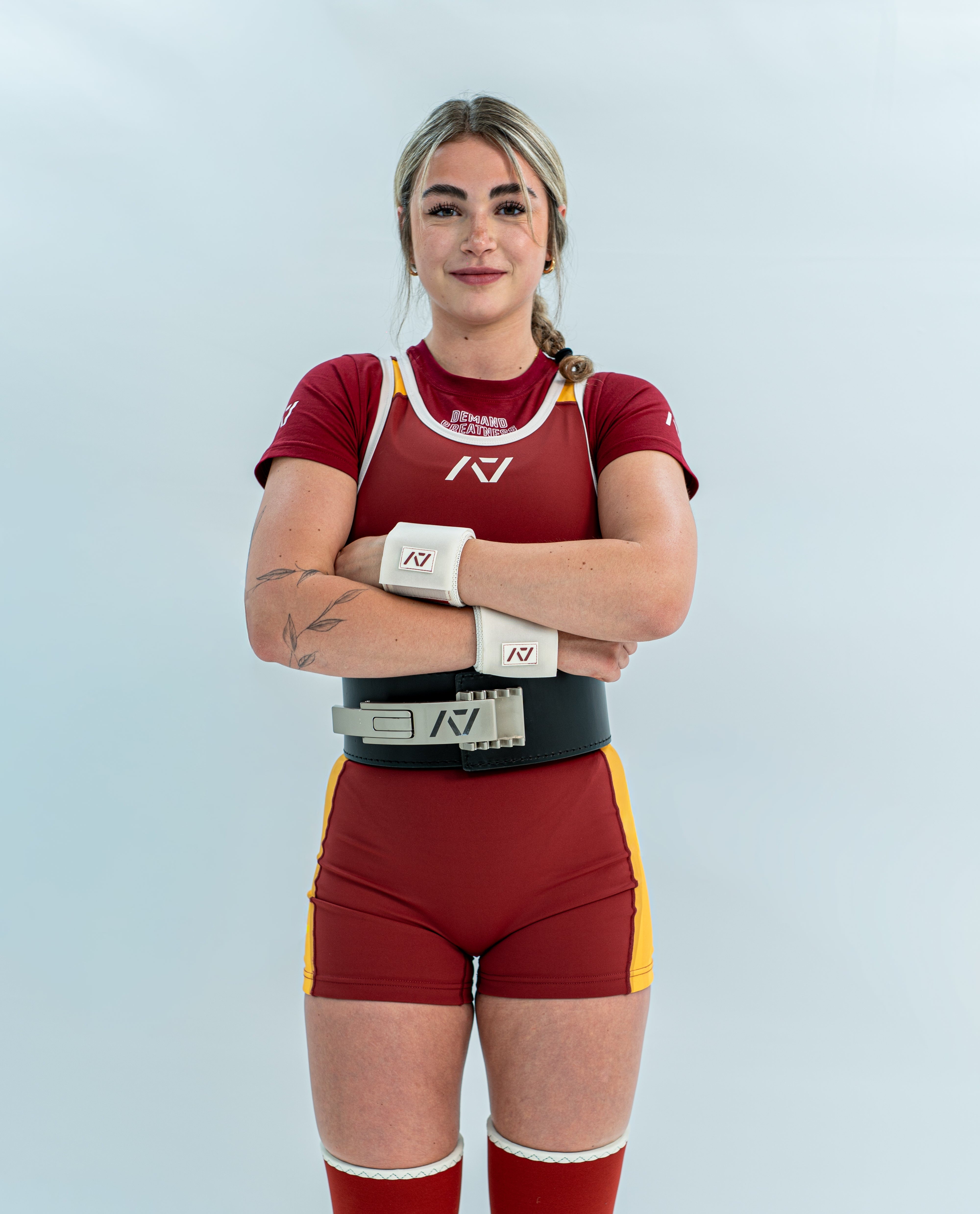 Female wearing a red and yellow rausch singlet with a white background