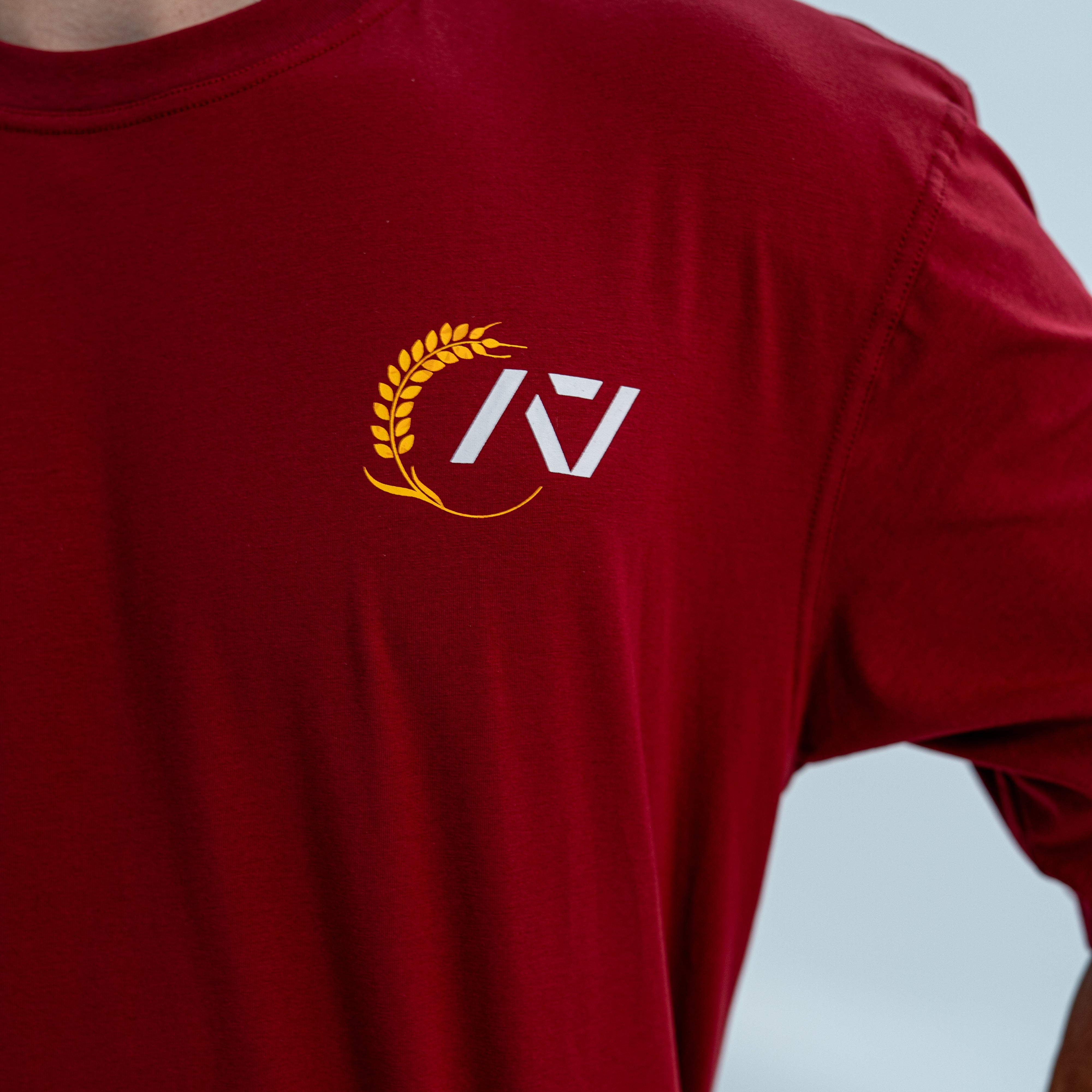 Red unisex over-fit shirt with a logo on a light gray background