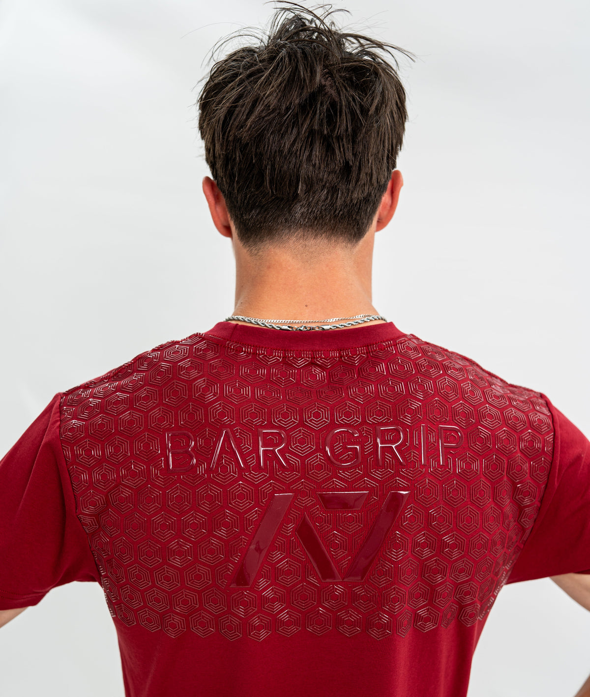 Male wearing a red Bar Grip Shirt with a Bar Grip technology on the upper back against a white background