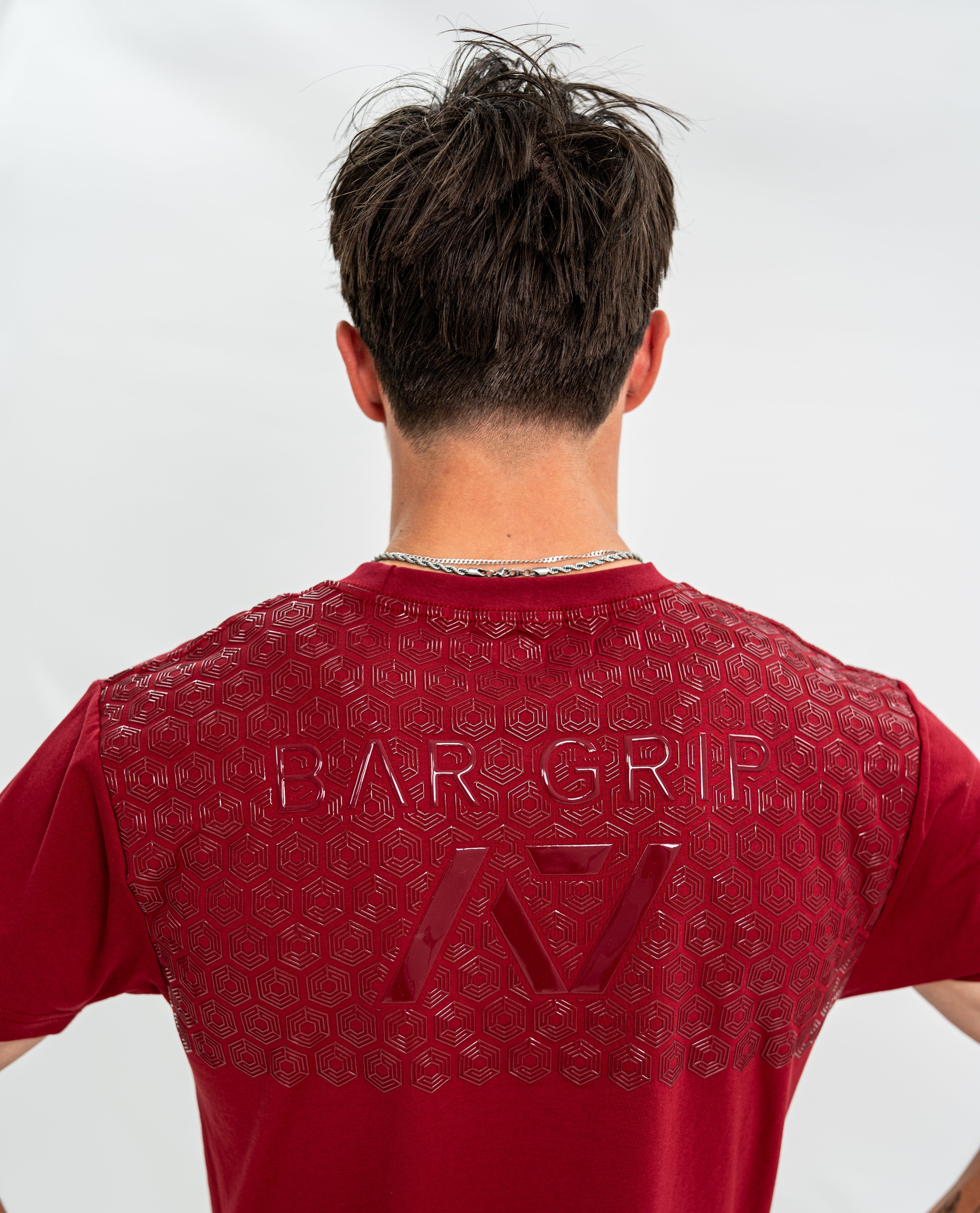 Male wearing a red Bar Grip Shirt with a Bar Grip technology on the upper back against a white background