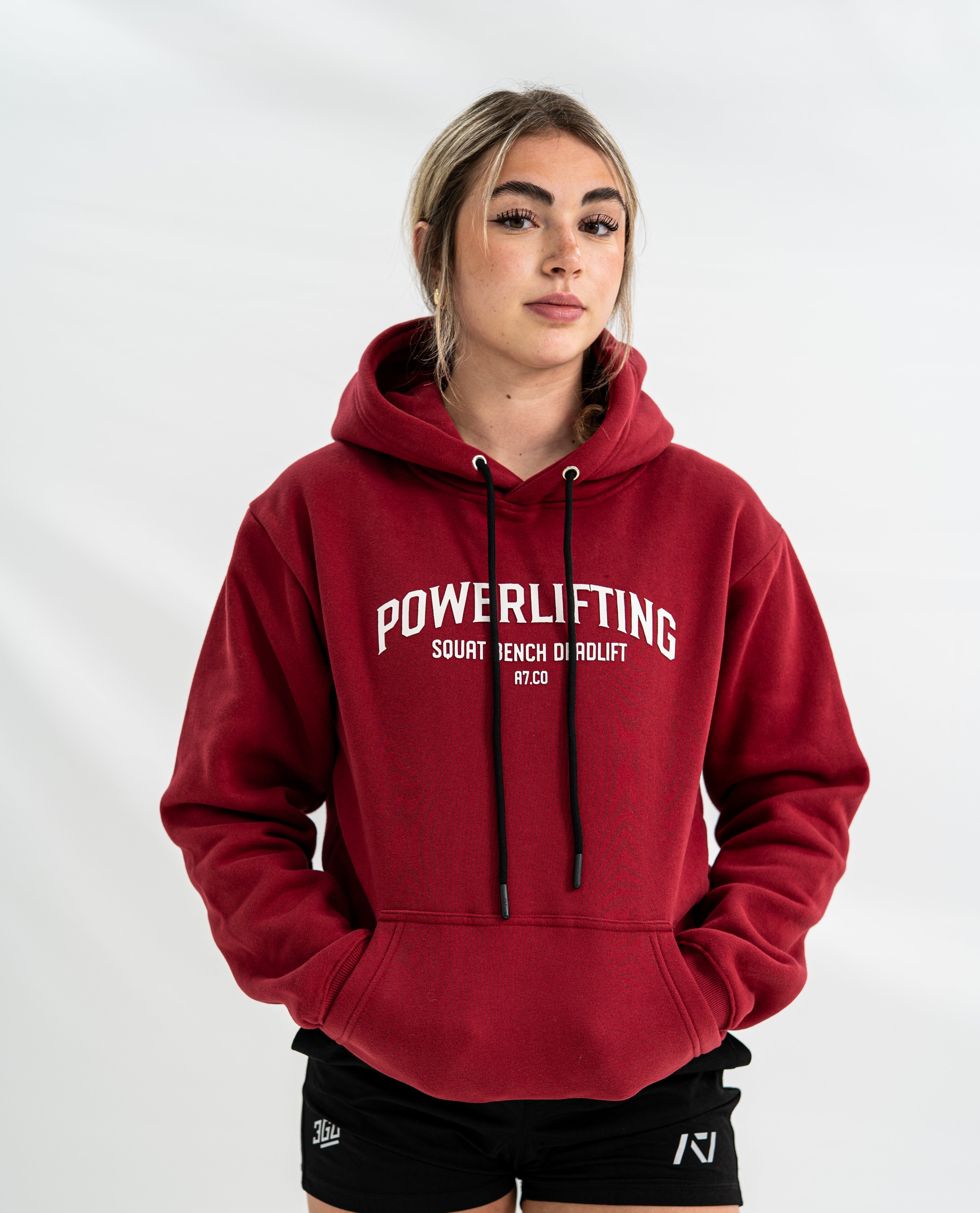 Female wearing a red 'Powerlifting' Bar Grip hoodie on a white background
