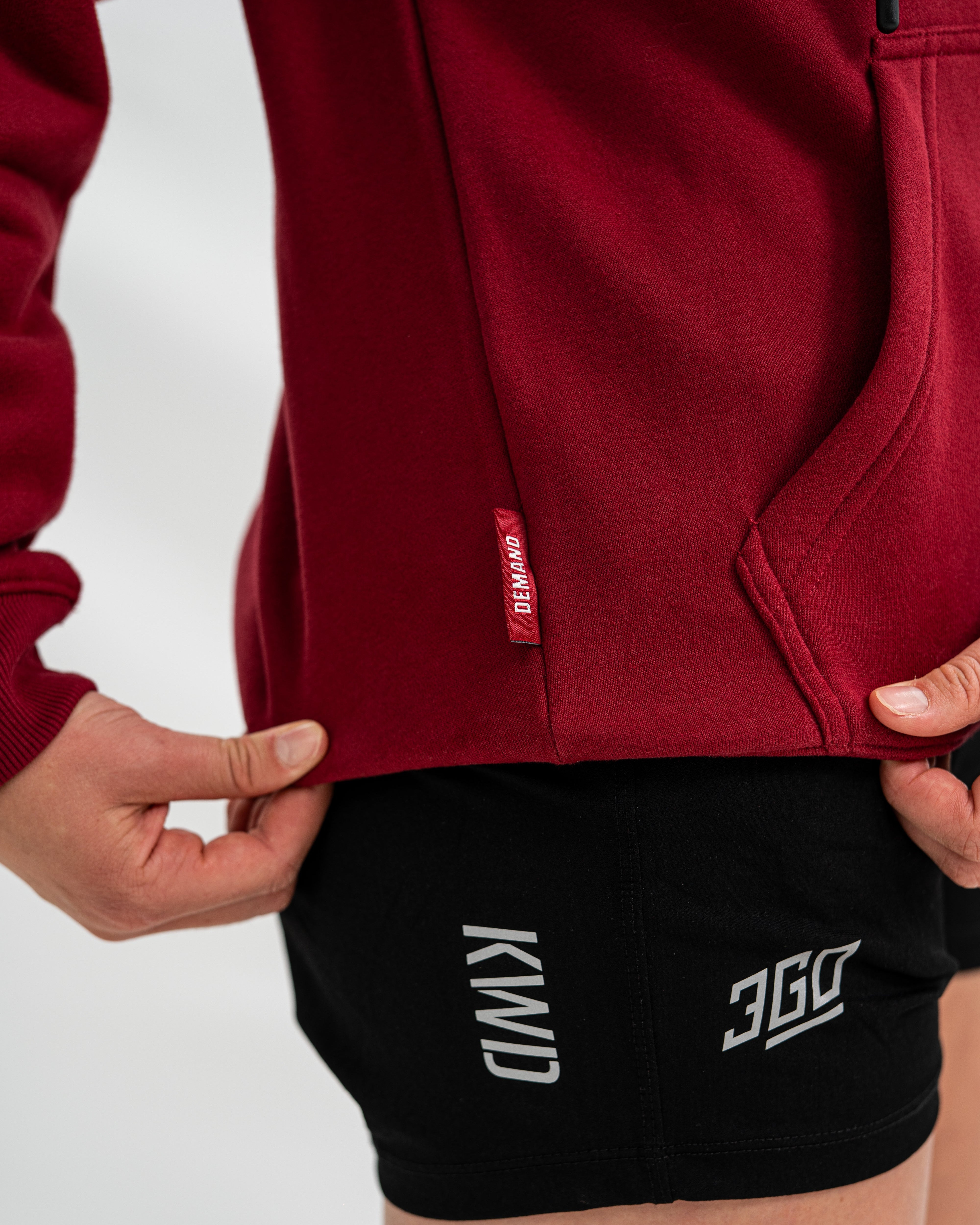 Red Bar Grip hoodie with a brand logo and black shorts with visible branding on a white background