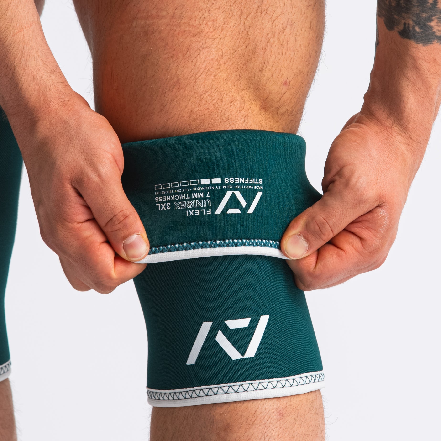 Close up of Hourglass Knee Sleeves - Flexi - Emerald folded showing label and double-stitched seams.