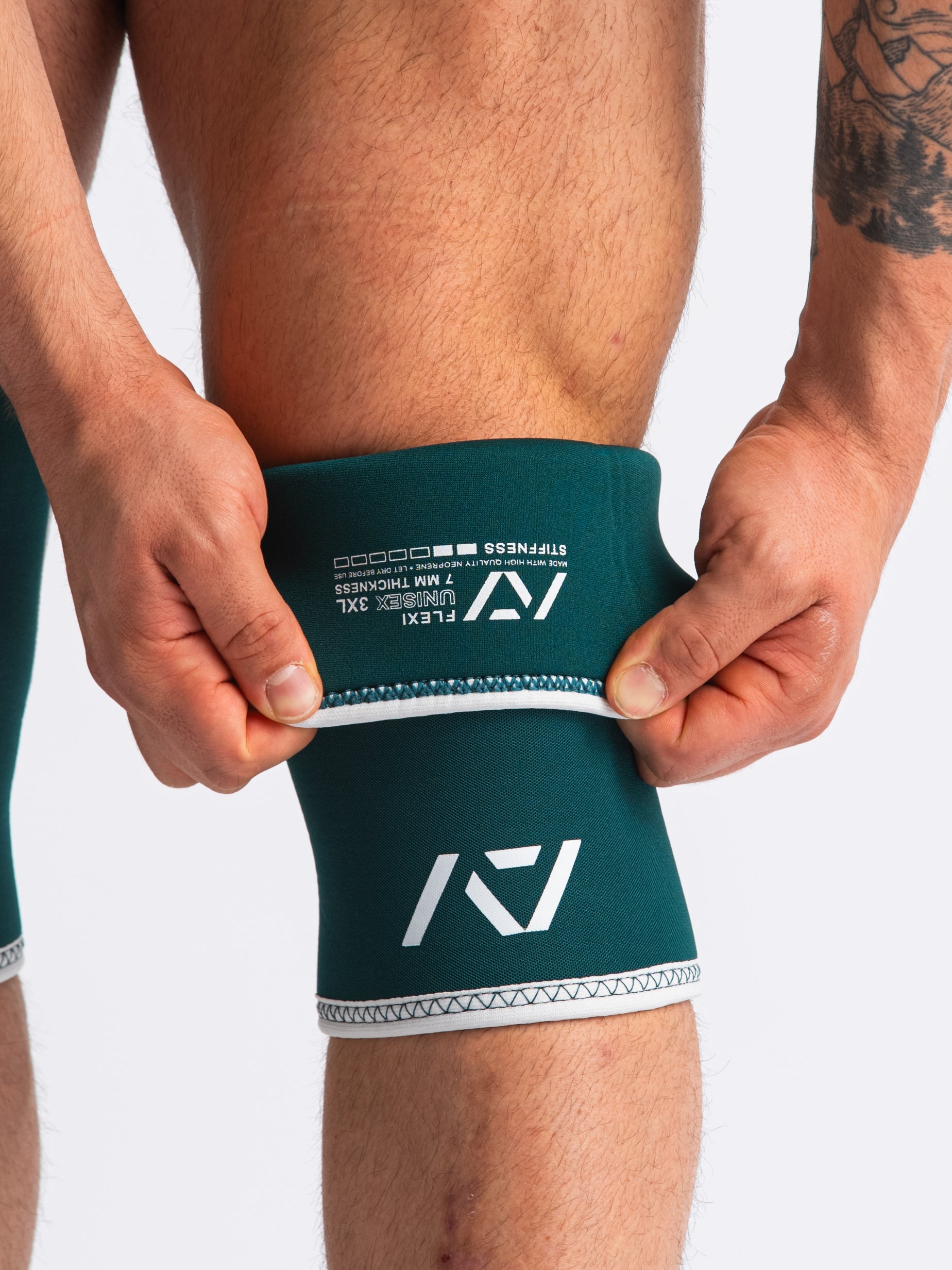 Close up of Hourglass Knee Sleeves - Flexi - Emerald folded showing label and double-stitched seams.