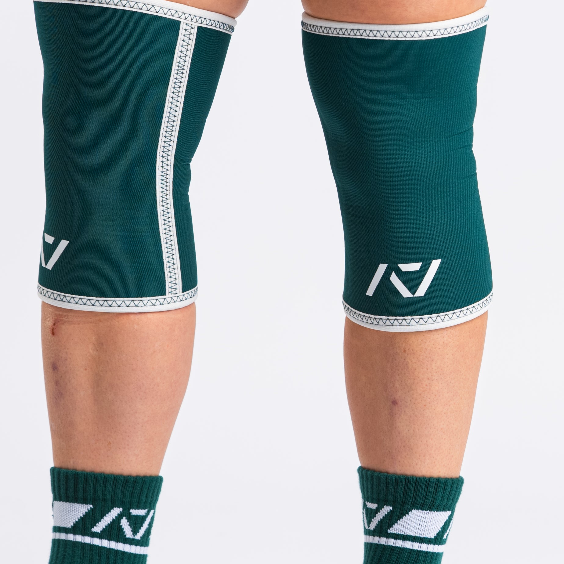 Side view of lifter executing stood with A7 Hourglass Knee Sleeves – Emerald Forás, highlighting snug fit and support during powerlifting.