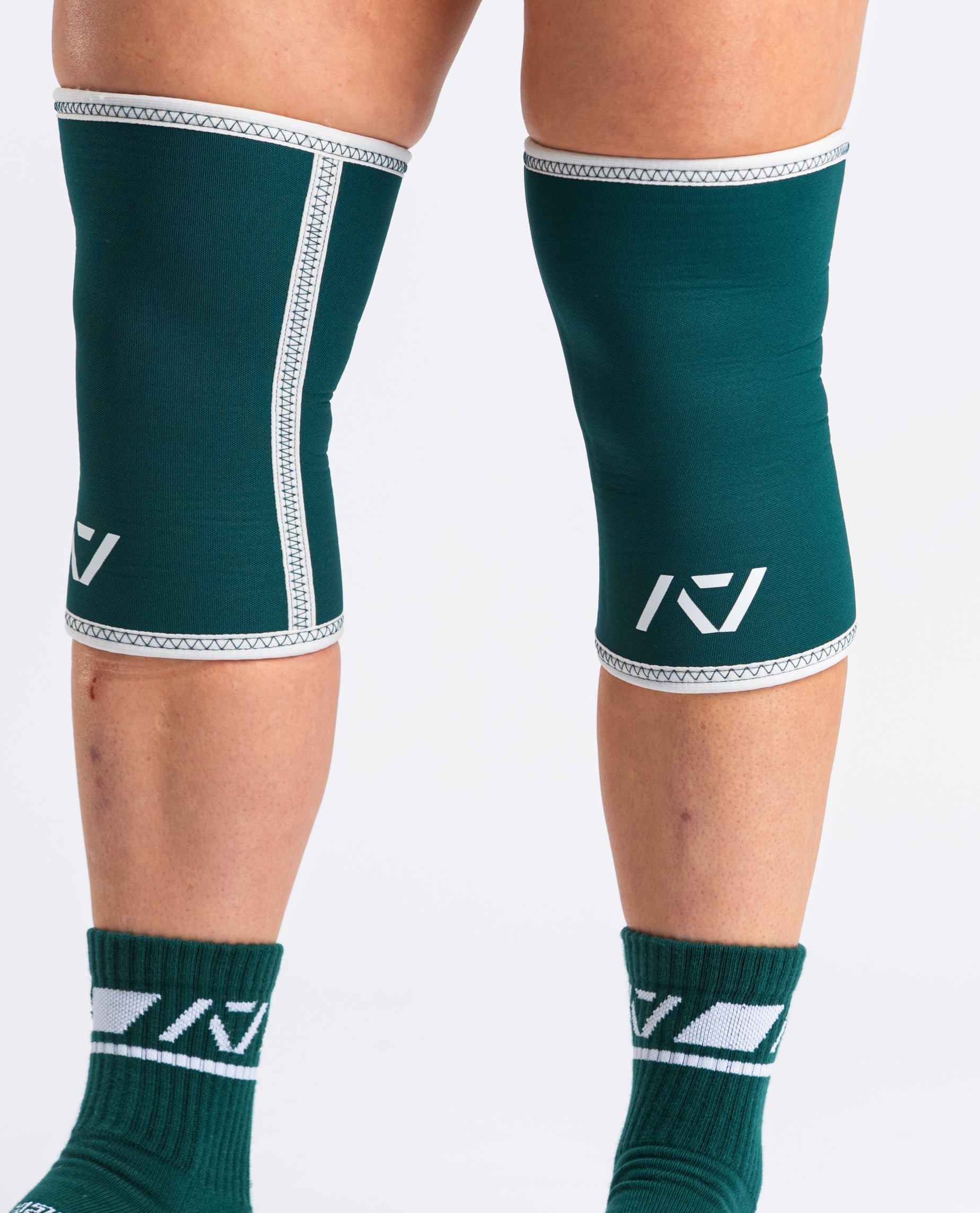 Side view of lifter executing stood with A7 Hourglass Knee Sleeves – Emerald Forás, highlighting snug fit and support during powerlifting.
