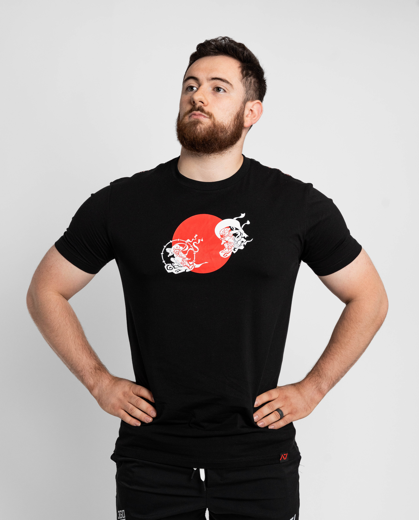 Man wearing a black t-shirt with a red and white graphic design on a light gray background