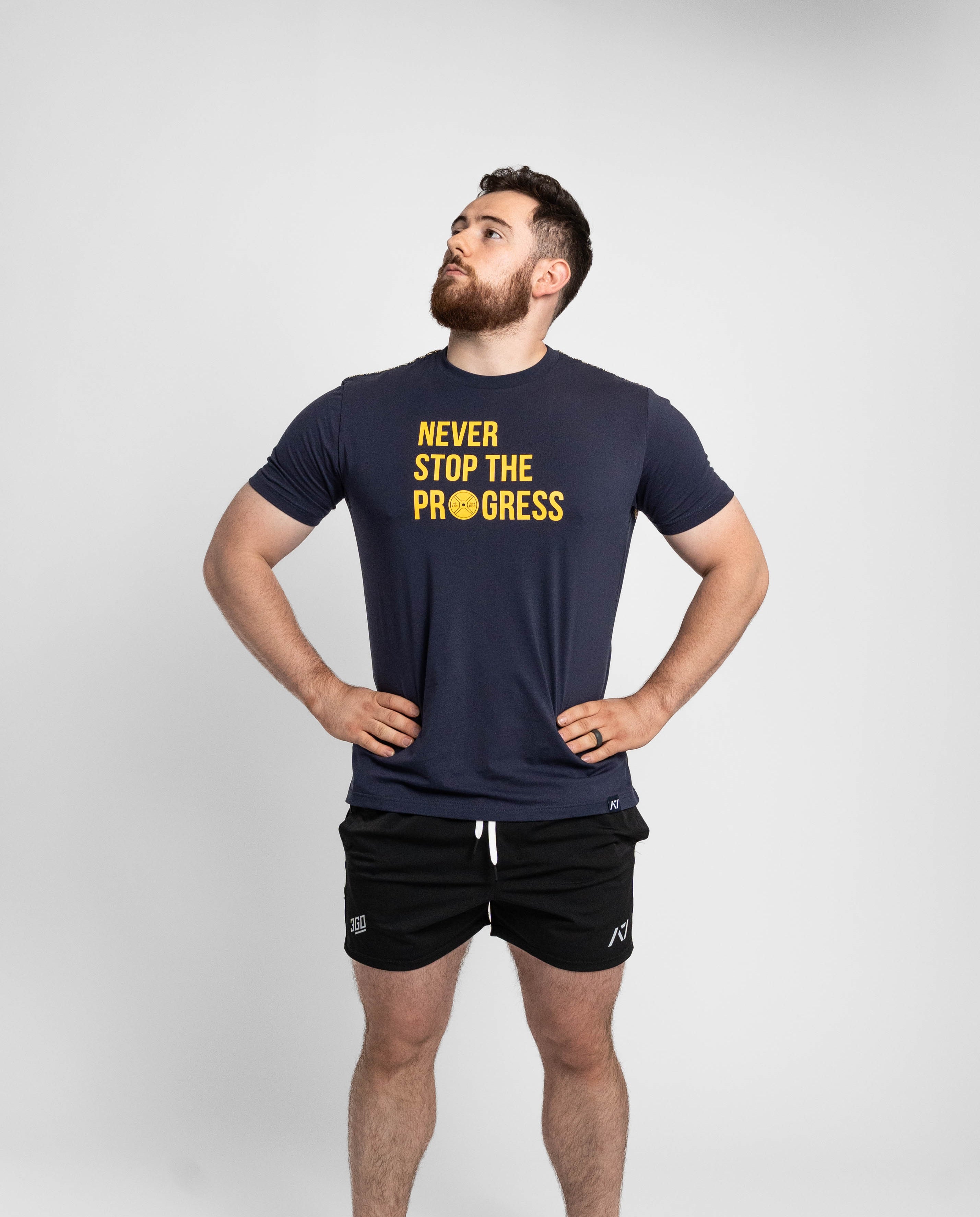 Man wearing a navy t-shirt with 'Never Stop The Progress' text on a white background