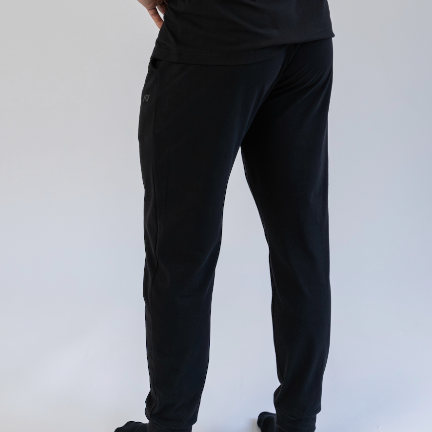 Person wearing black pants and a black shirt on a white background