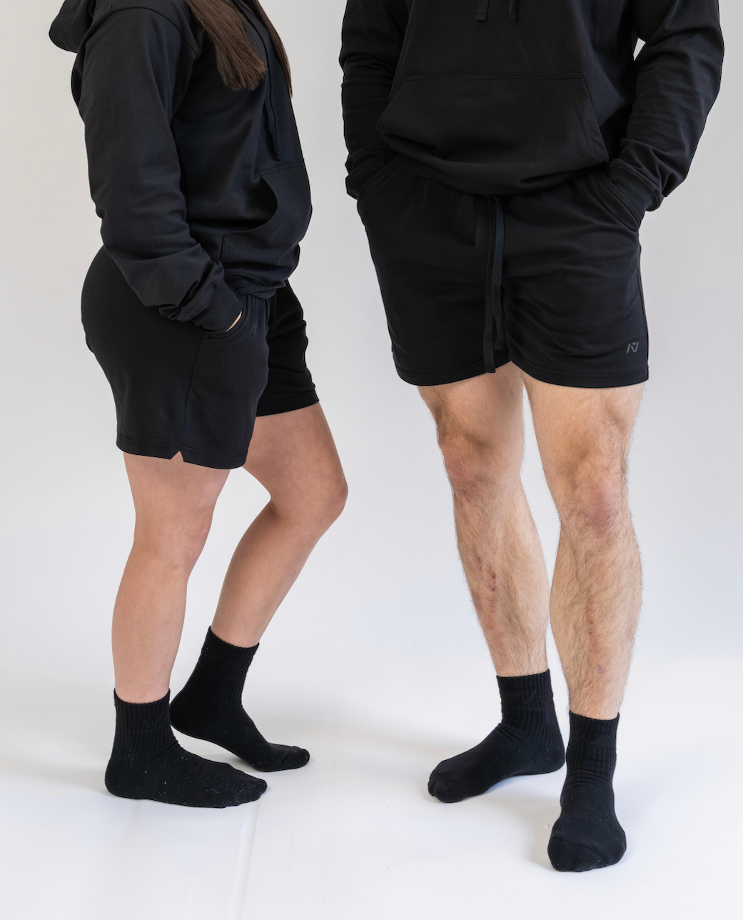 Two people wearing black athletic wear on a white background