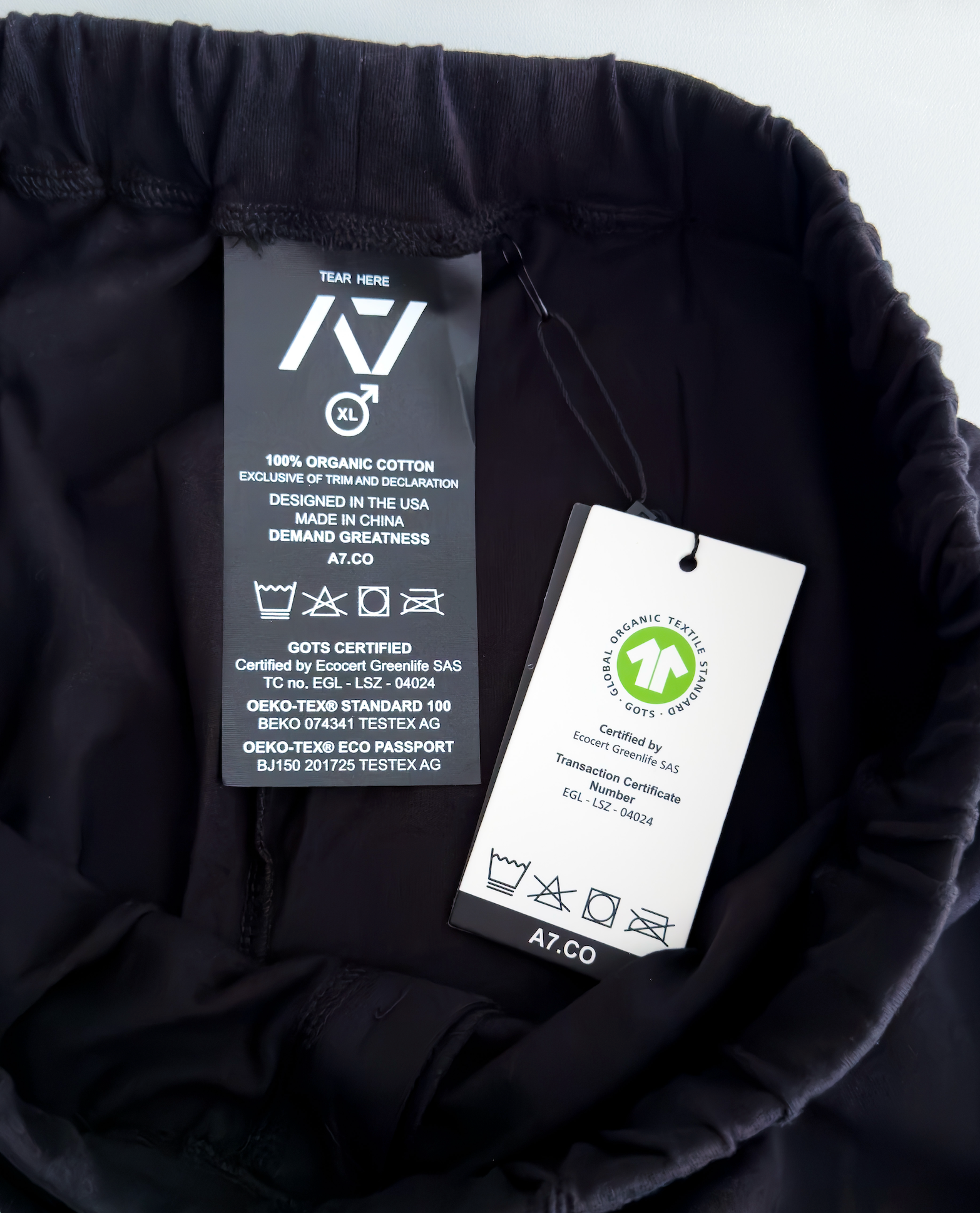 Clothing tag with certification details on a black fabric background