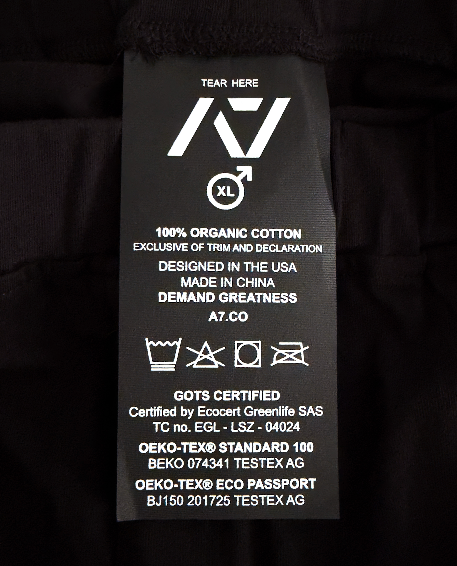 Clothing label with text and symbols on a black background