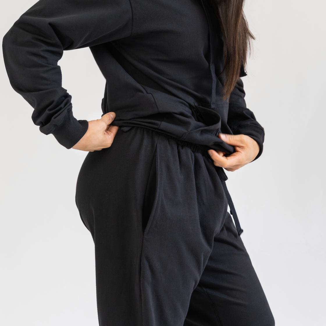 Person wearing a black outfit on a plain background