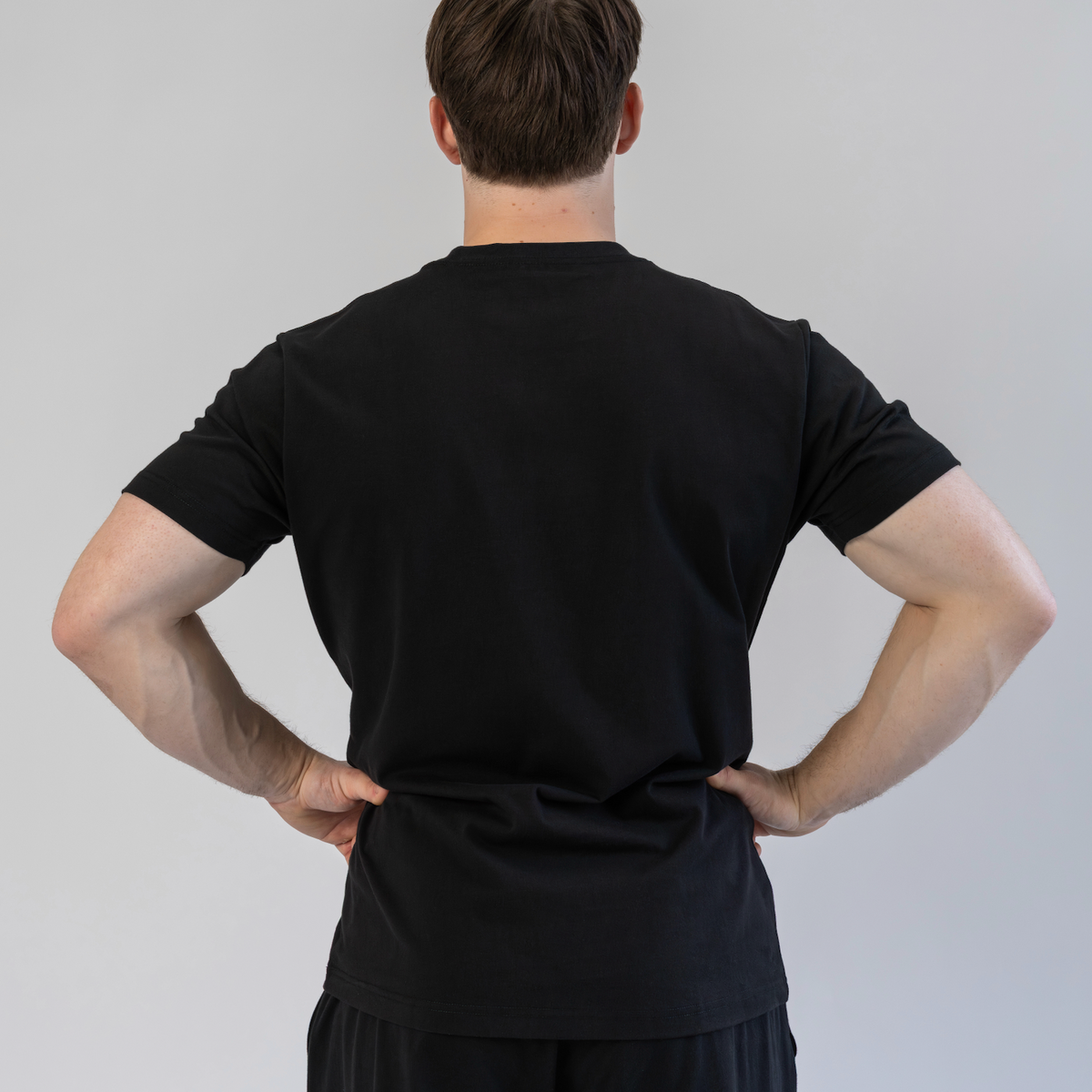 Person wearing a black outfit against a plain background