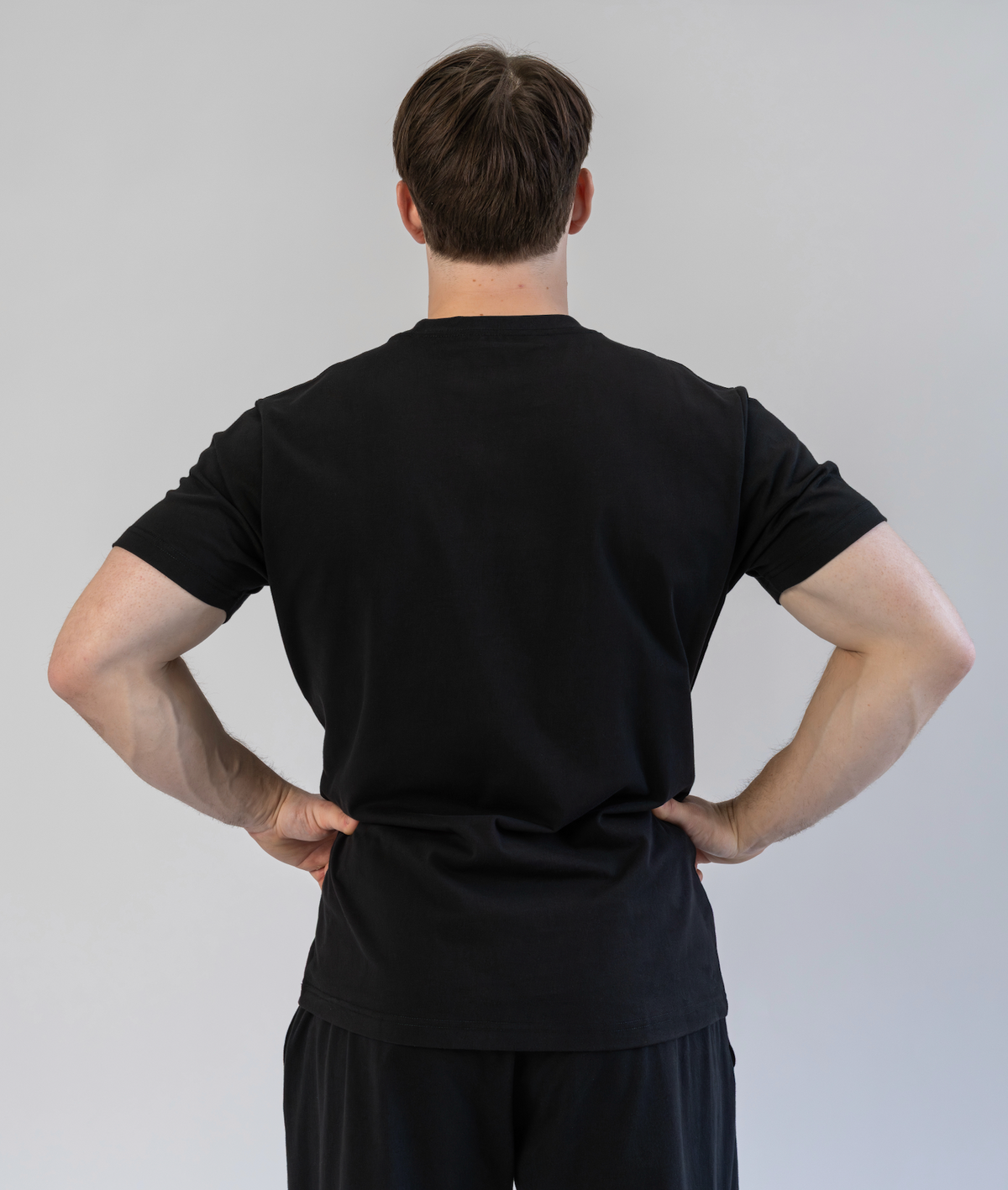 Person wearing a black outfit against a plain background