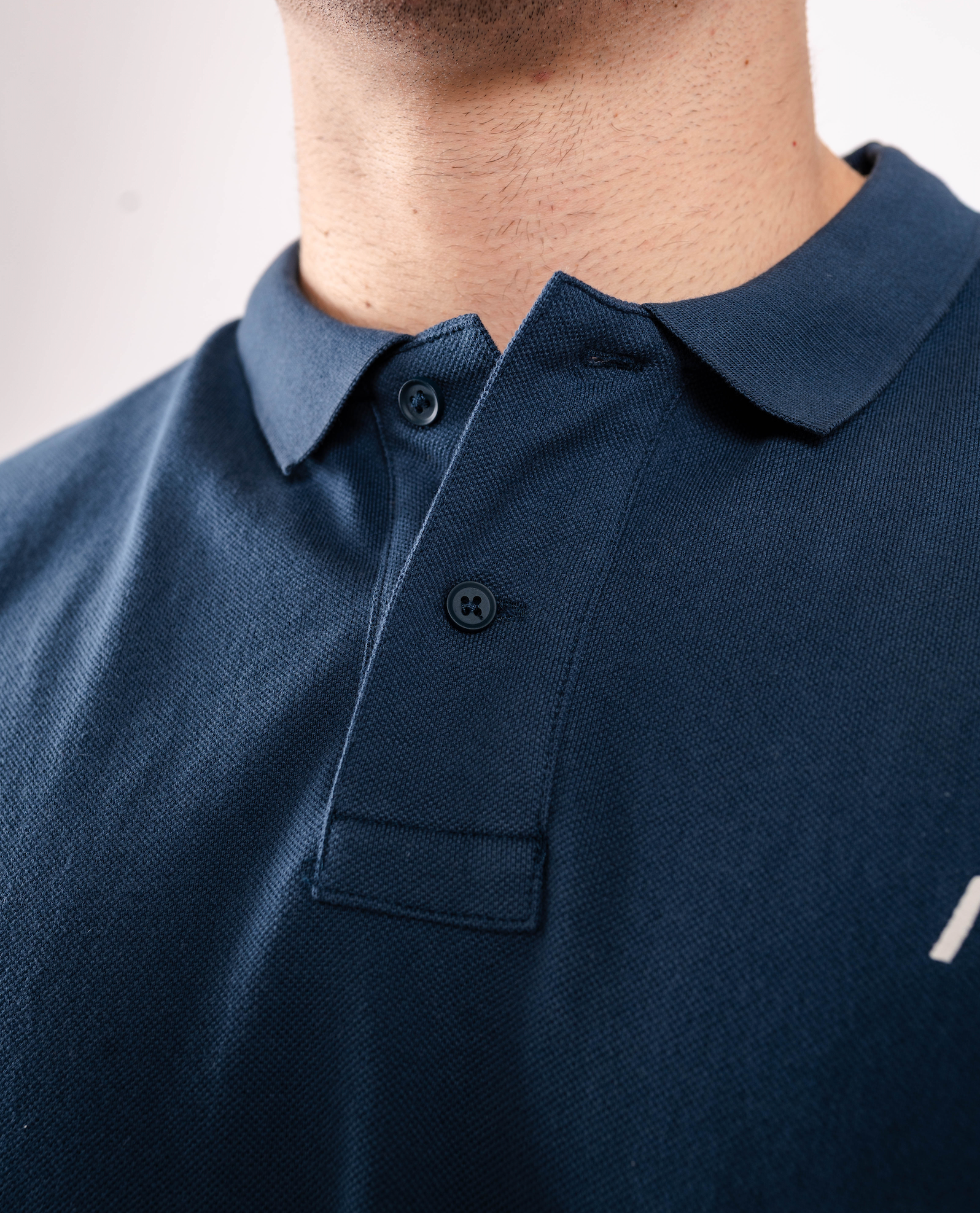 Close-up of the rib-knit polo collar on the A7 Cotton Polo in Tides Blue.