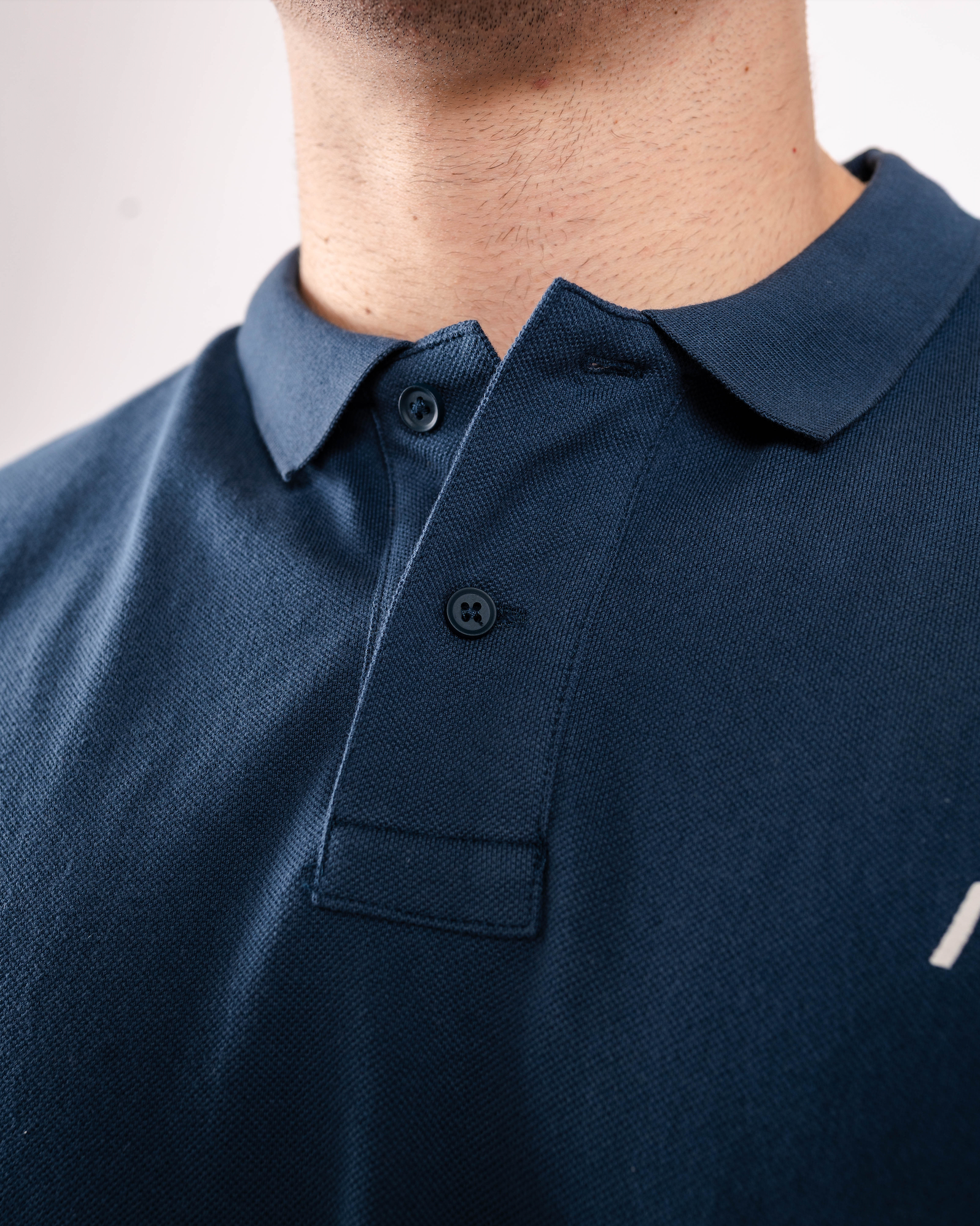 Close-up of the rib-knit polo collar on the A7 Cotton Polo in Tides Blue.