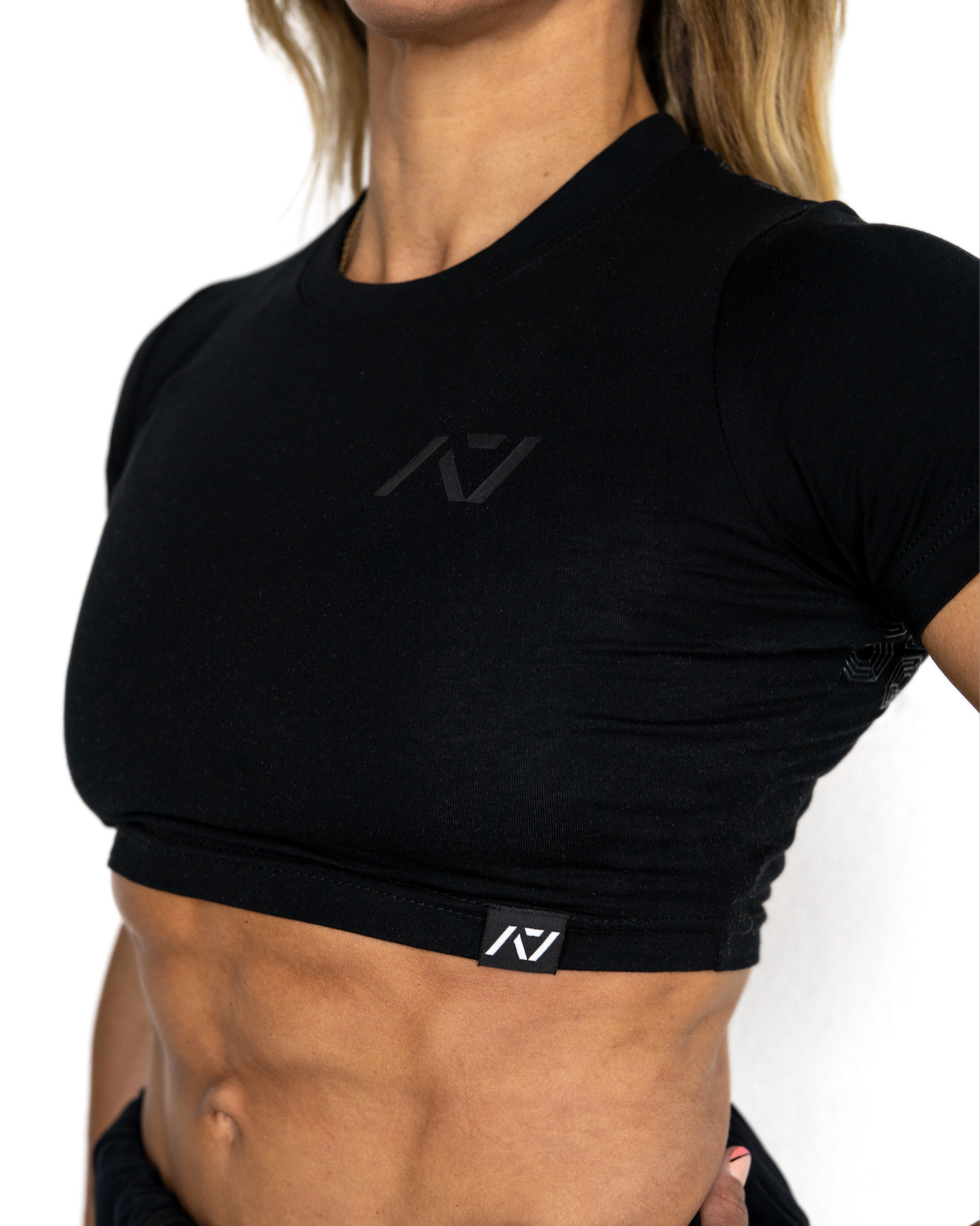 Person wearing a black athletic outfit with a visible brand logo on a white background