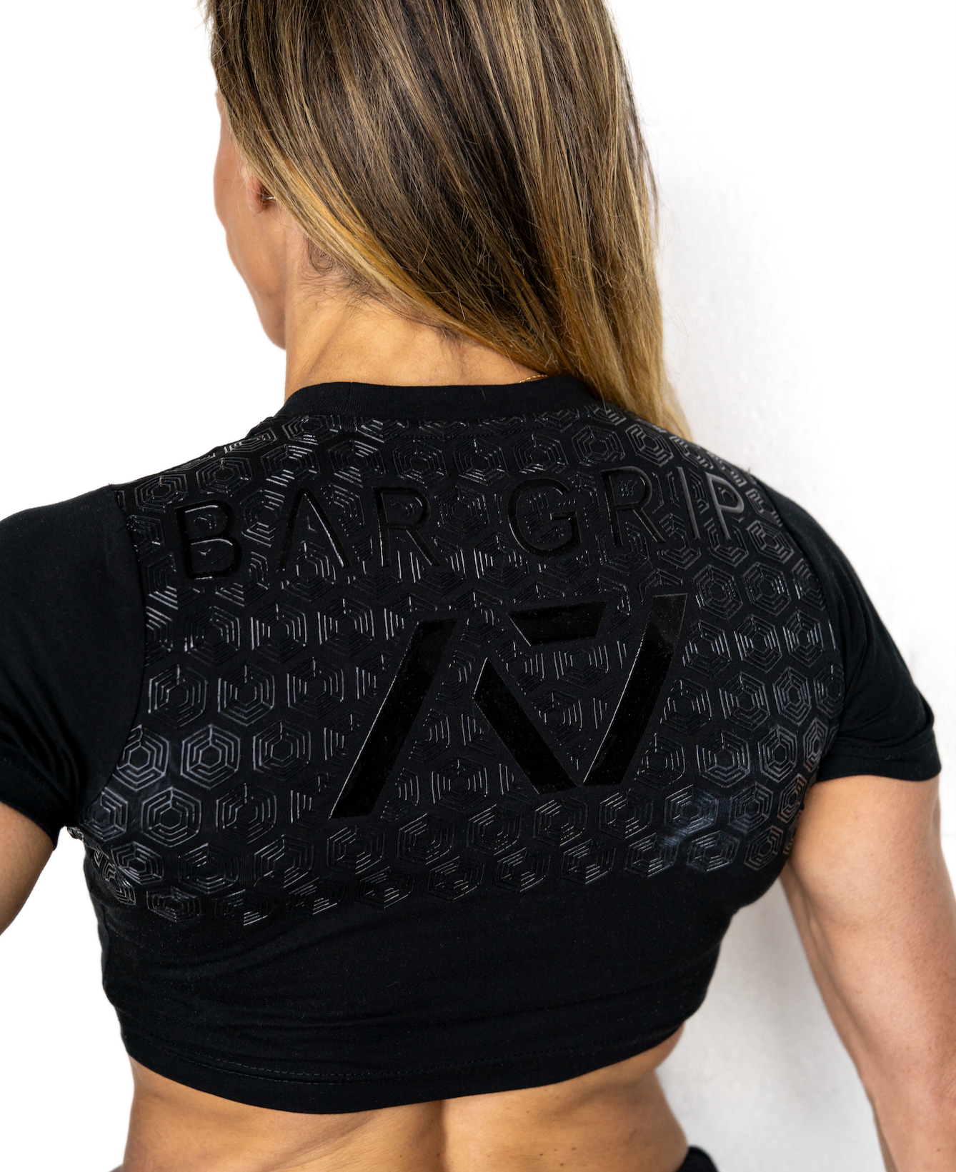 Person wearing a black athletic outfit with A7 bar grip on a white background