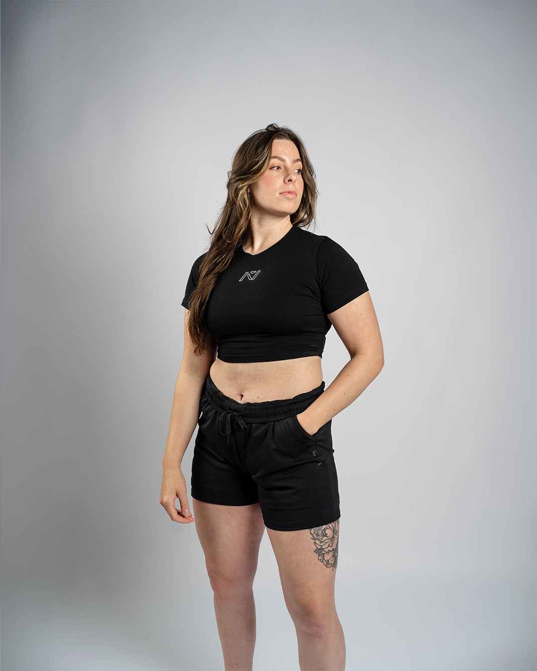 Athlete wearing the A7 Affirmation True-Fit Women's Crop – Domino demonstrating fit and style in a gym setting.