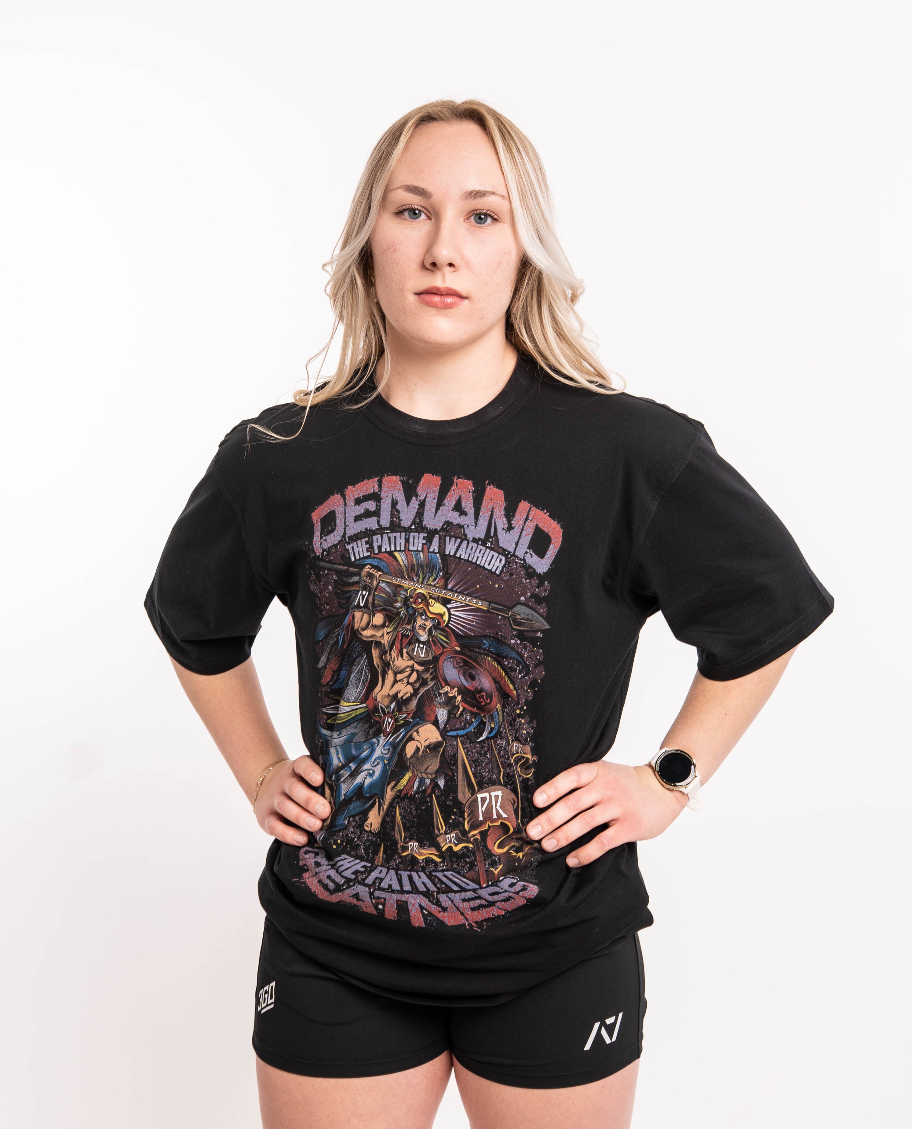 Front view of Aztec Warrior Over-Fit Unisex Shirt showcasing the detailed Aztec warrior design with eagle headdress and "Demand Greatness" spear.