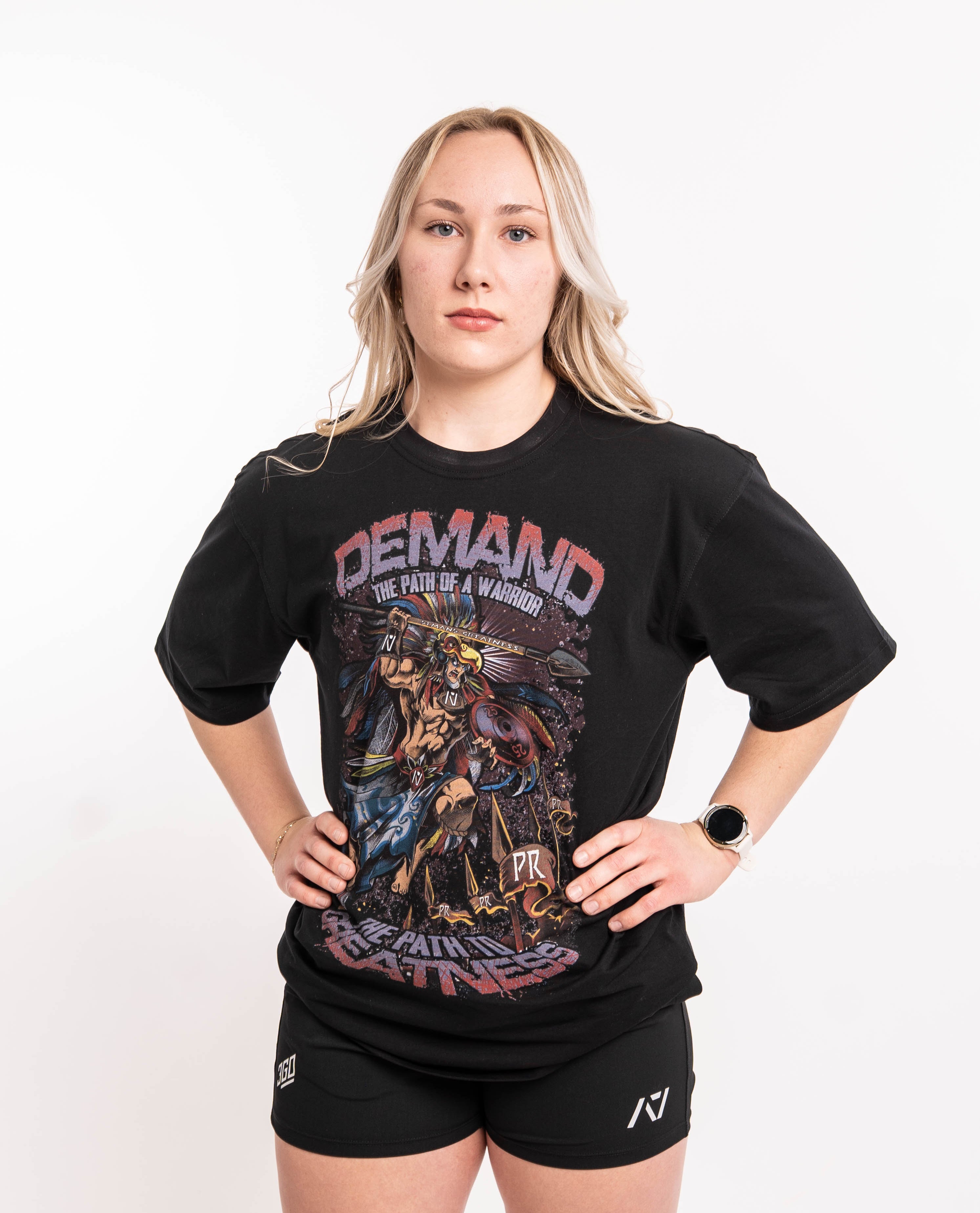 Front view of Aztec Warrior Over-Fit Unisex Shirt showcasing the detailed Aztec warrior design with eagle headdress and "Demand Greatness" spear.