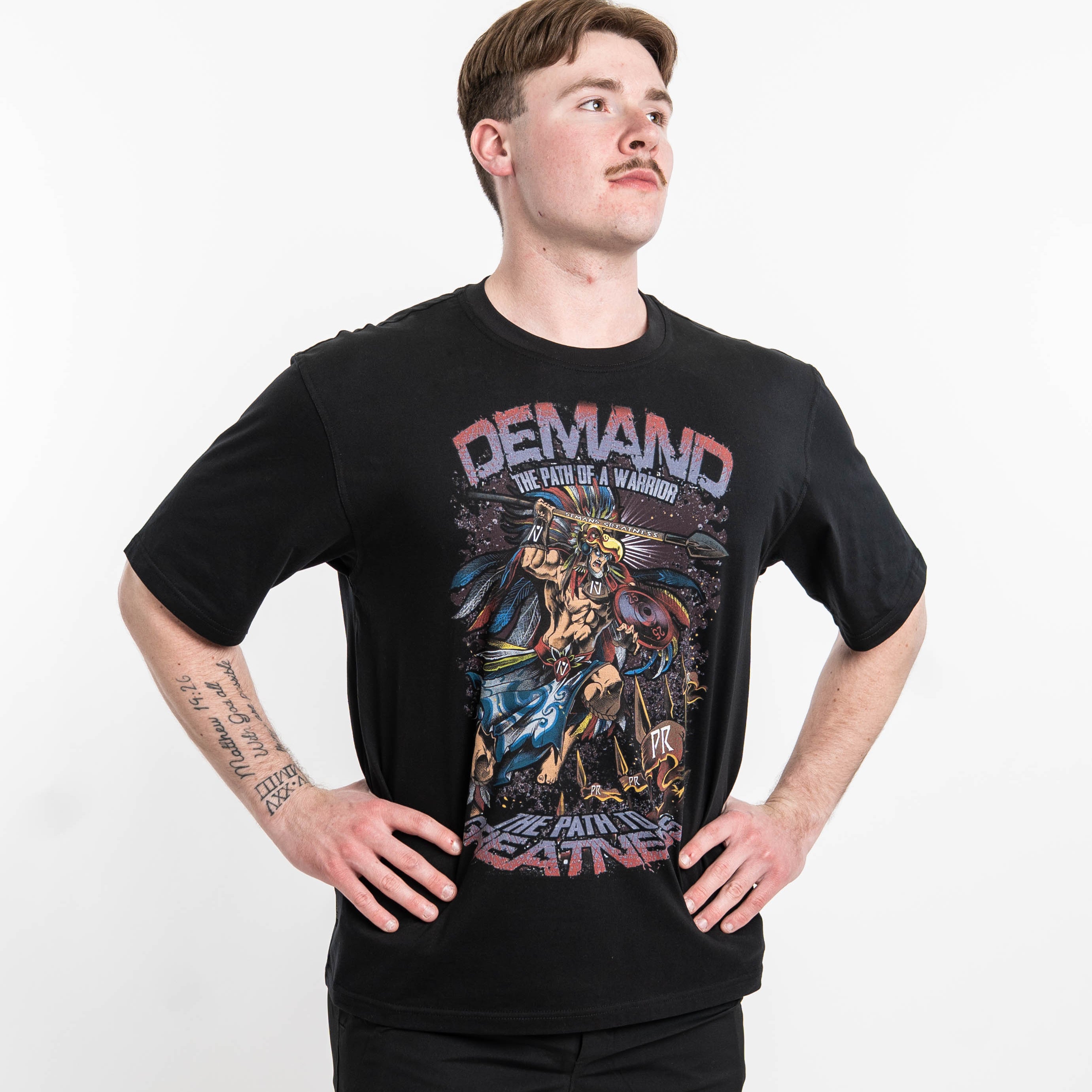 ront view of Aztec Warrior Over-Fit Unisex Shirt showcasing the detailed Aztec warrior design with eagle headdress and "Demand Greatness" spear.