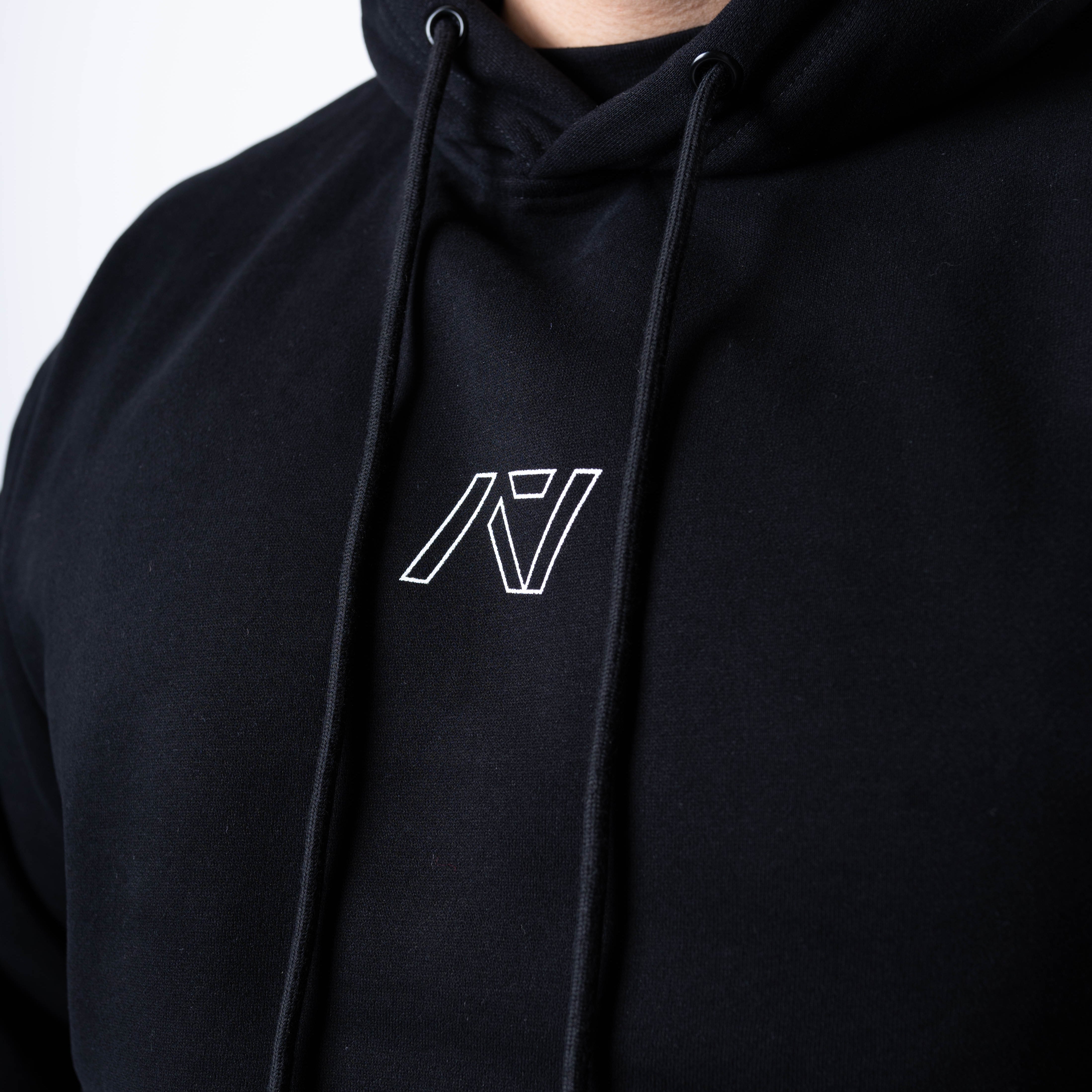 Close-up of the white A7 logo on the chest of the Built By Hoodie – Black, printed on soft fleece fabric for a clean, minimalist look.