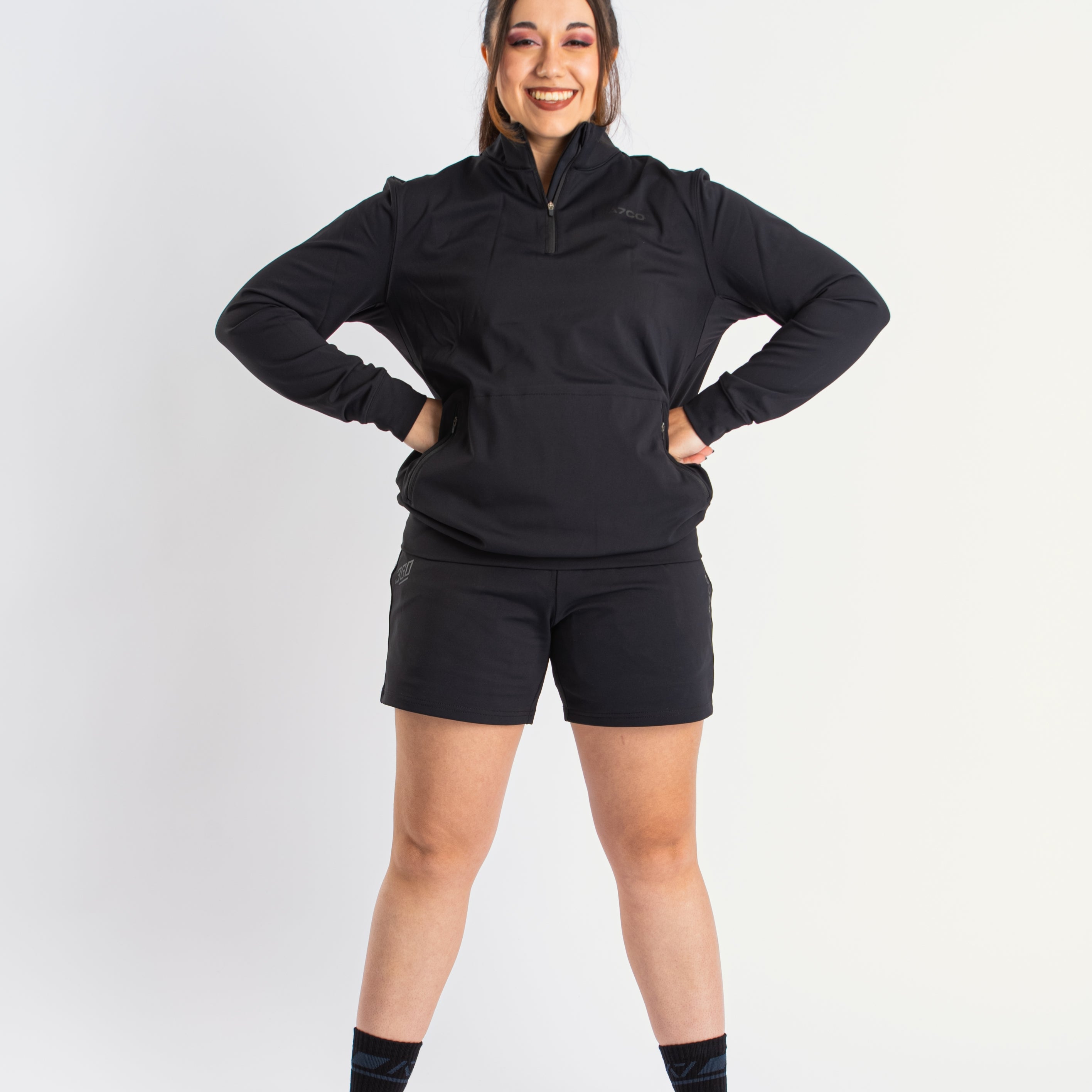 Athlete wearing the A7 Cobra Quarter Zip Jacket in Stealth, demonstrating fit and style in a gym setting.