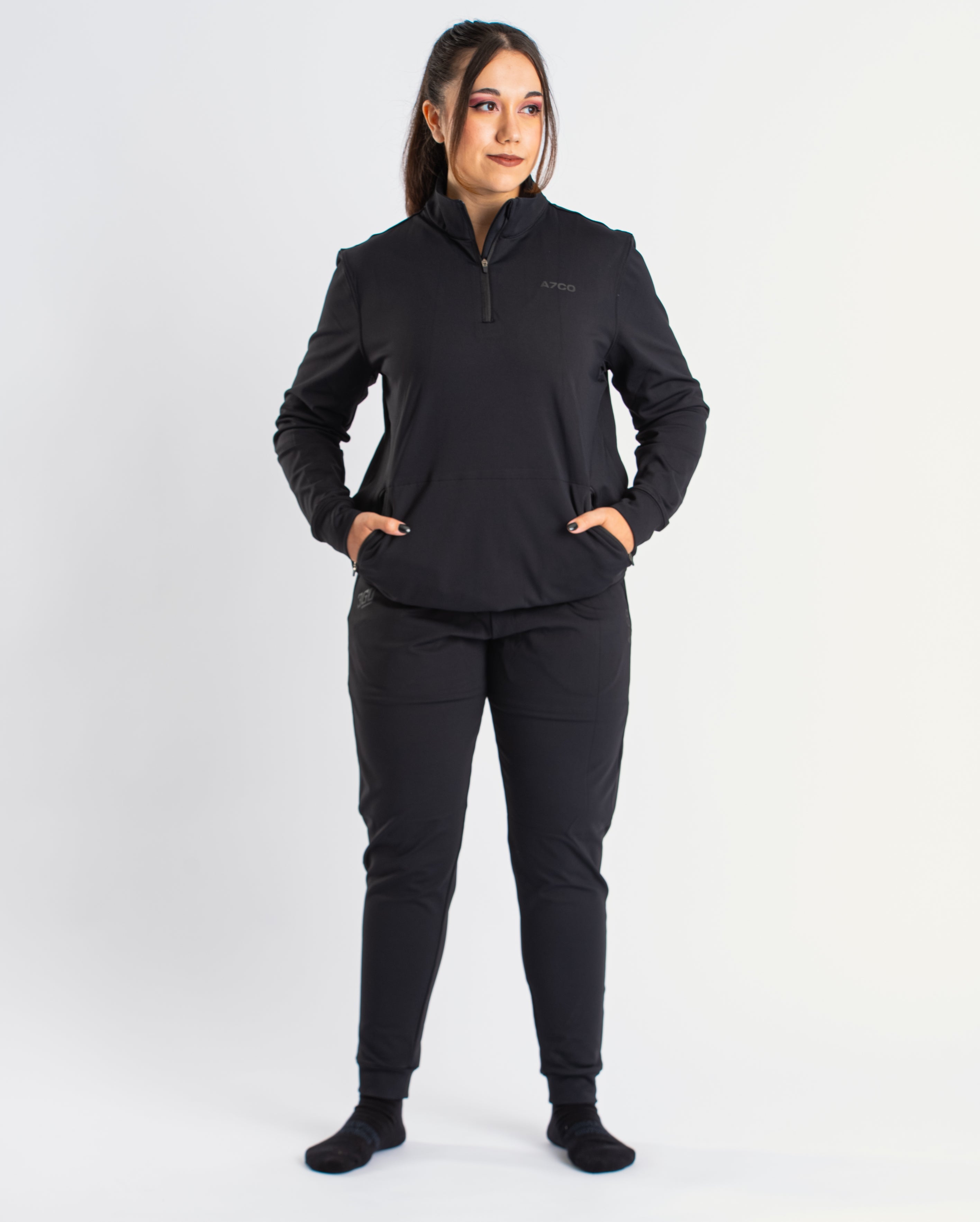 Athlete wearing the A7 Cobra Quarter Zip Jacket in Stealth, demonstrating fit and style in a gym setting.