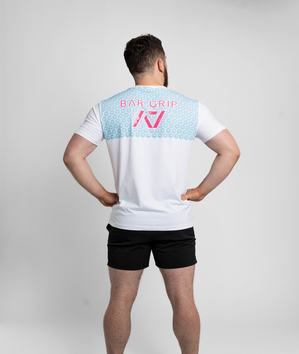 Person wearing a white t-shirt with a7 Bar Grip on the back against a gray background