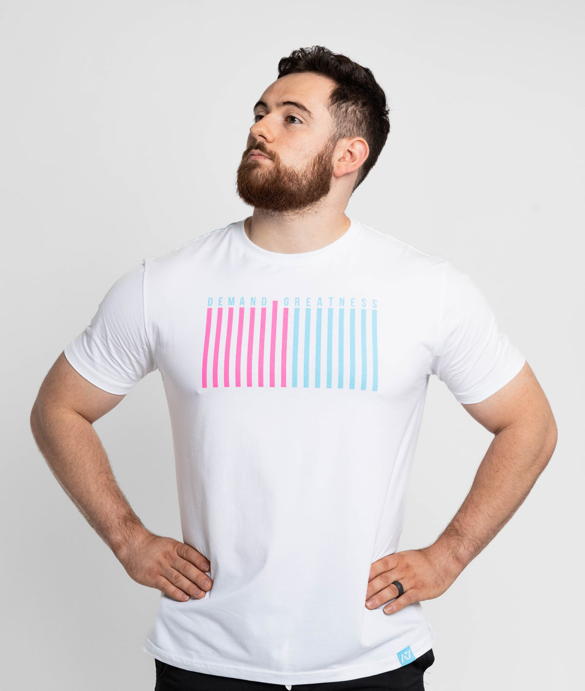 Man wearing a white t-shirt with pink and blue striped design on a light gray background