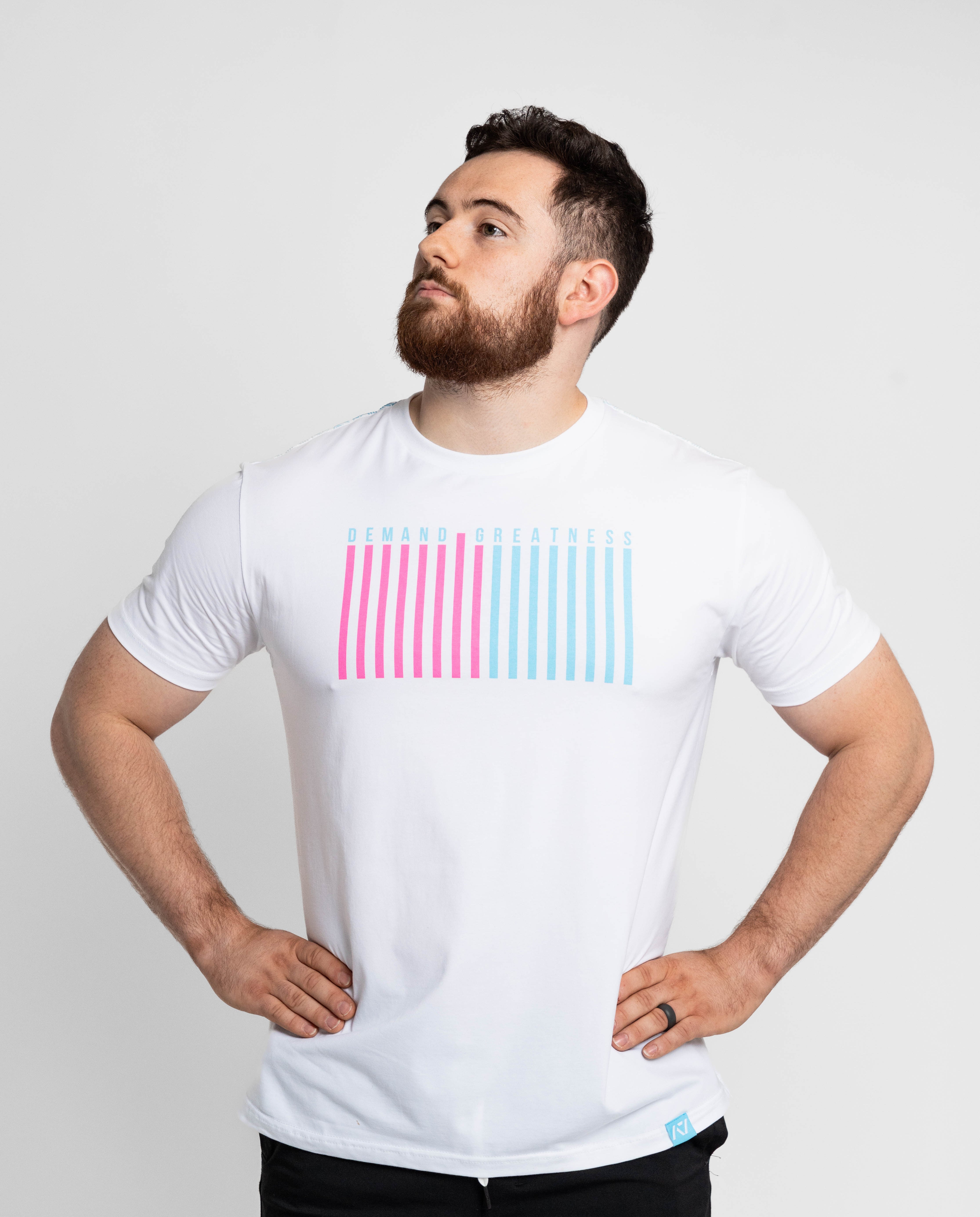 Man wearing a white t-shirt with pink and blue striped design on a light gray background