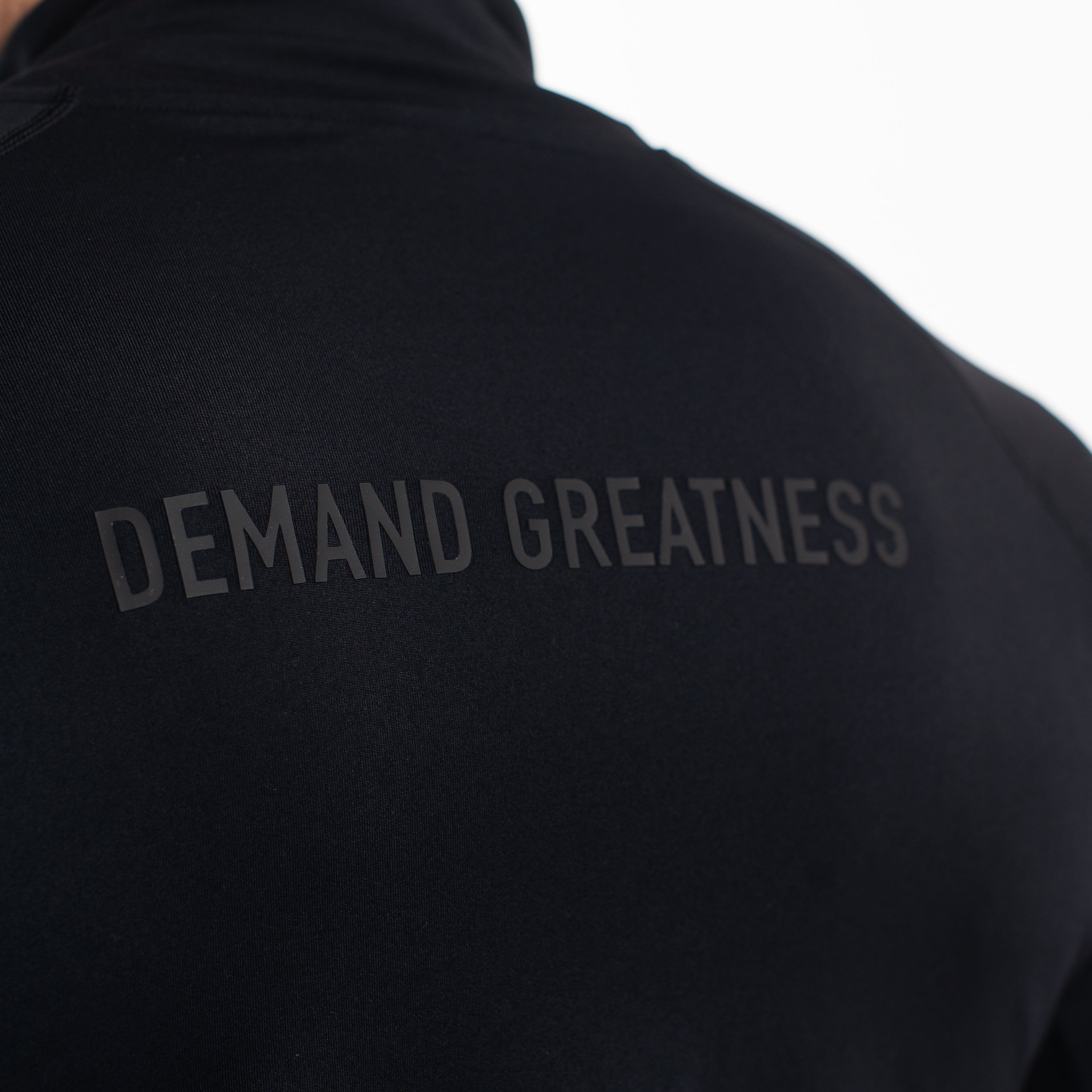 Back view of A7 Defy Jacket – Stealth, featuring the 3D “Demand Greatness” silicone graphic.