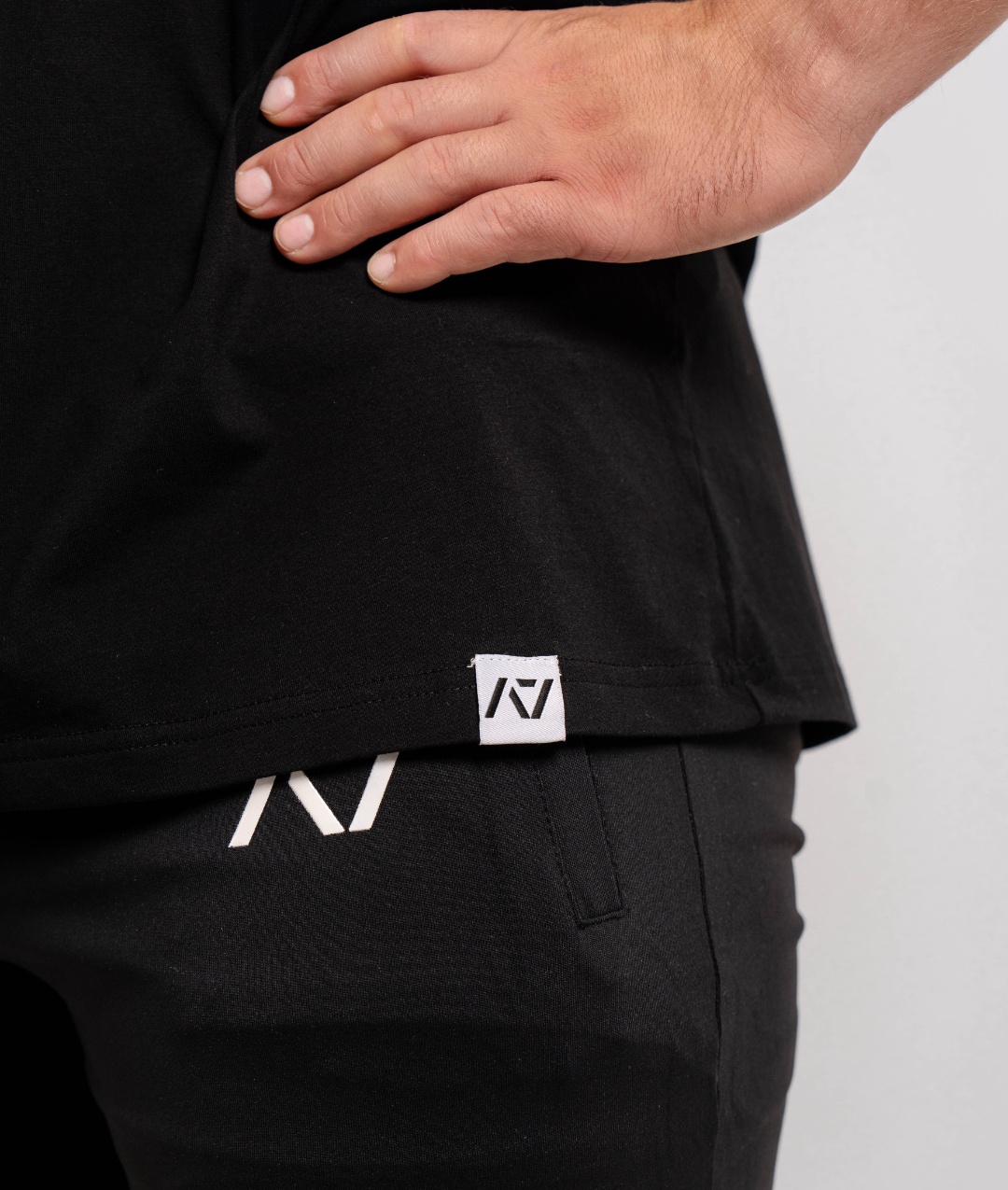 Close-up of the woven A7 hem tag at the bottom edge of the Domino shirt.