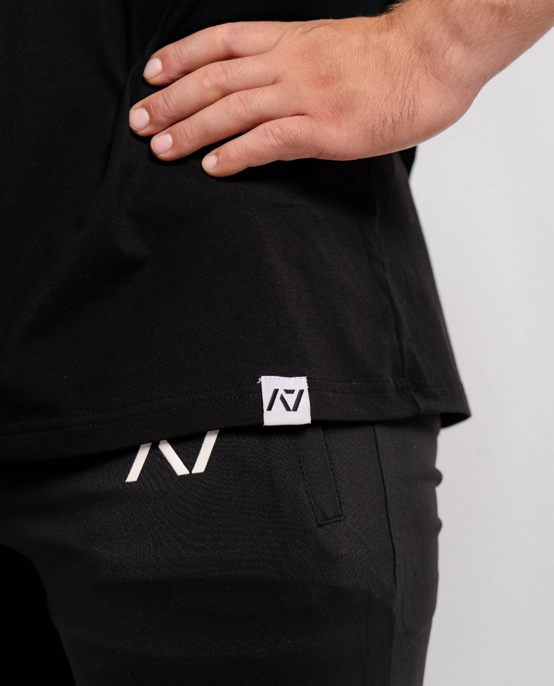 Close-up of the woven A7 hem tag at the bottom edge of the Domino shirt.