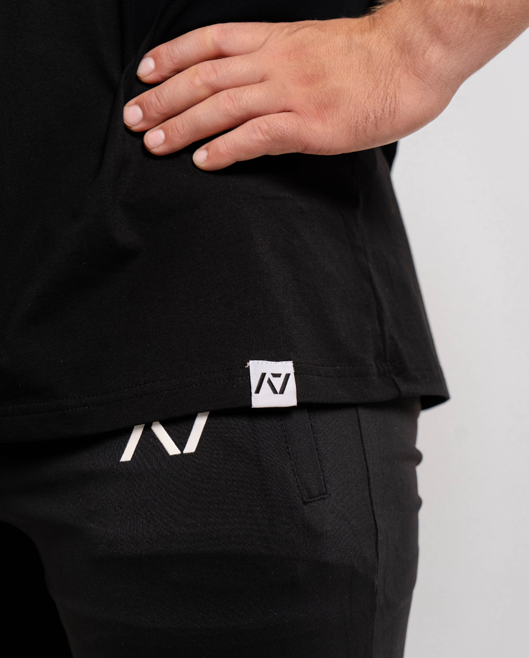 Close-up of the woven A7 hem tag at the bottom edge of the Domino shirt.
