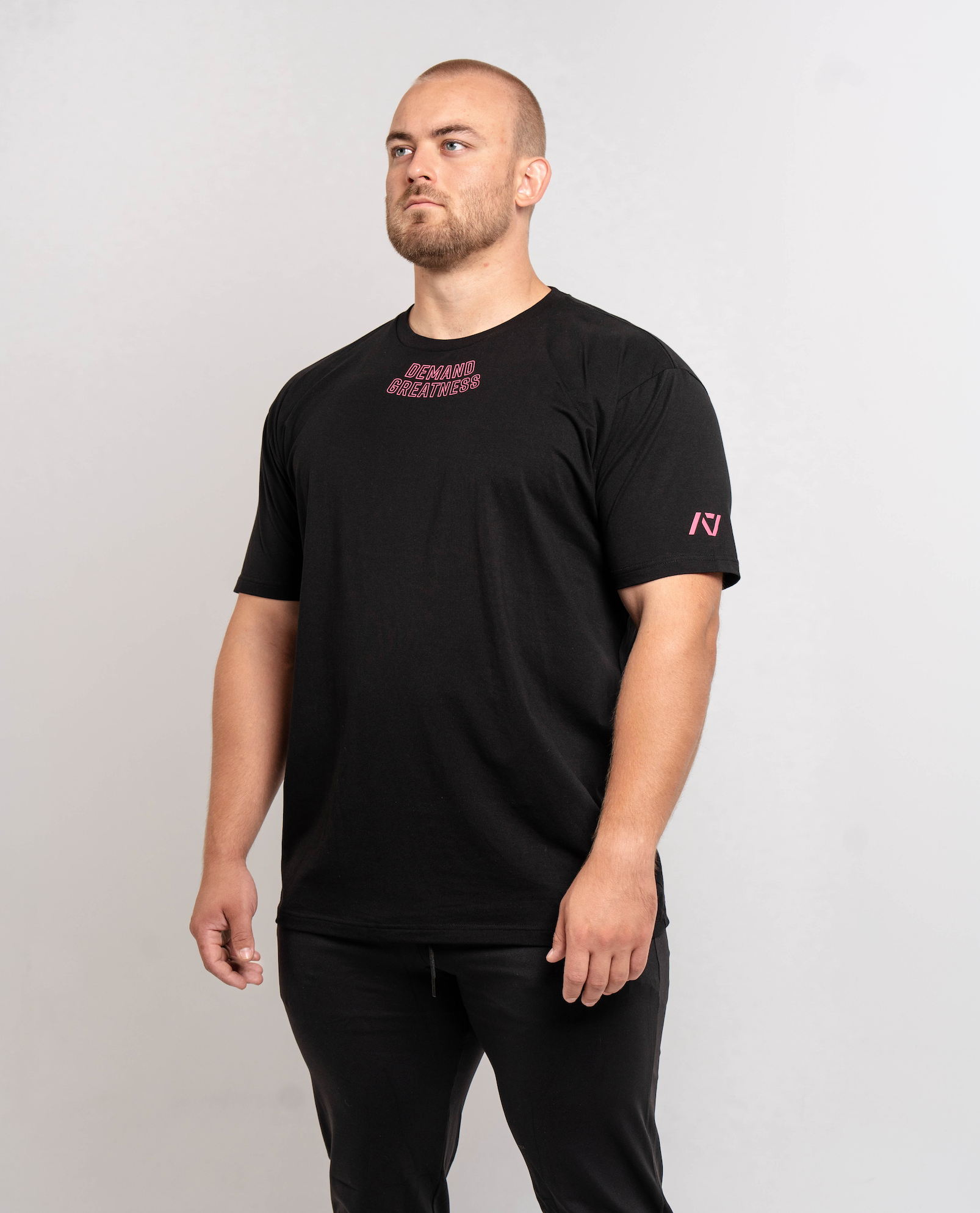 Front view of Flamingo True‑Fit Meet Shirt displaying “Demand Greatness” chest print and athletic torso fit.