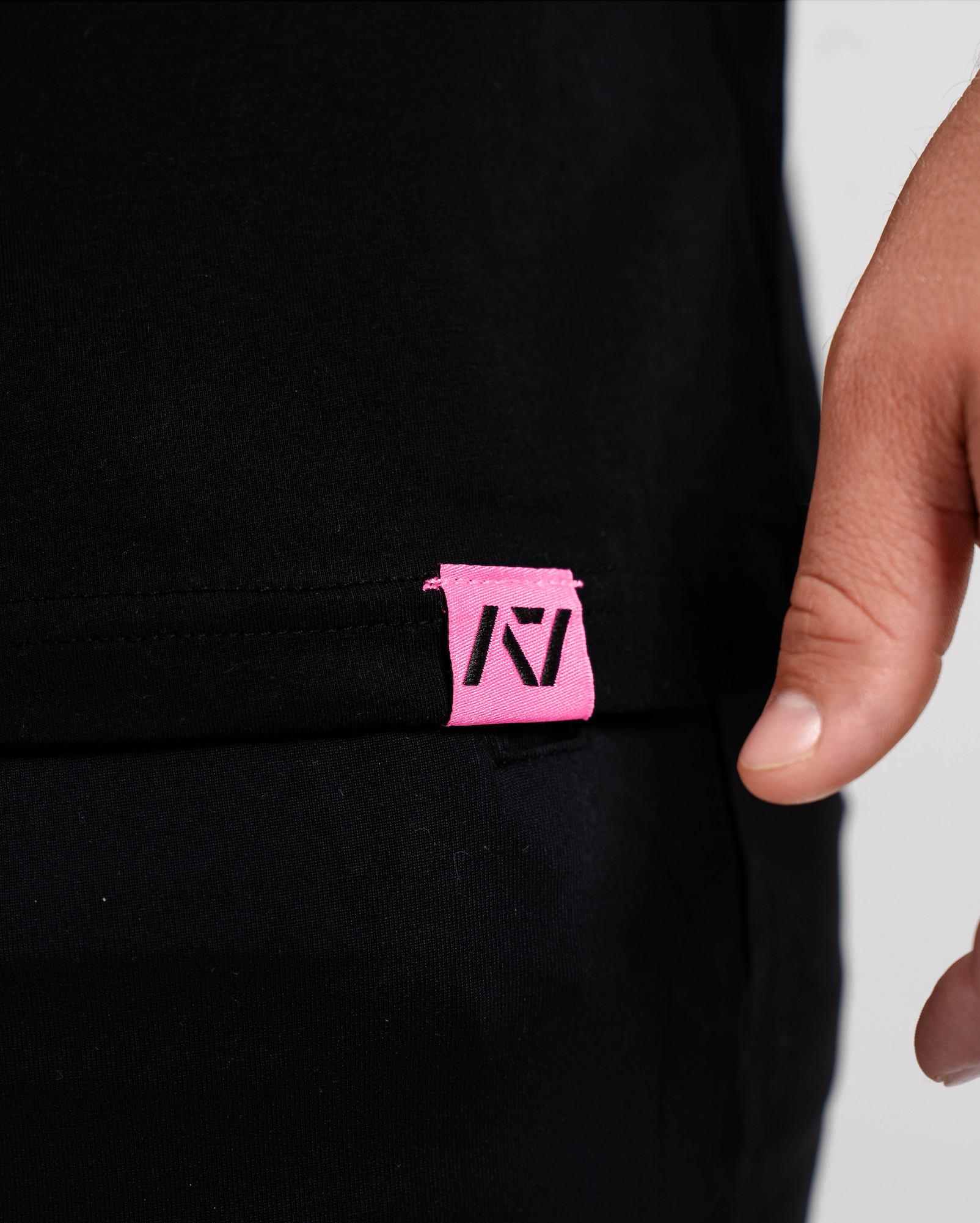 Close-up of woven A7 hem tag along the bottom hem of the Flamingo shirt.