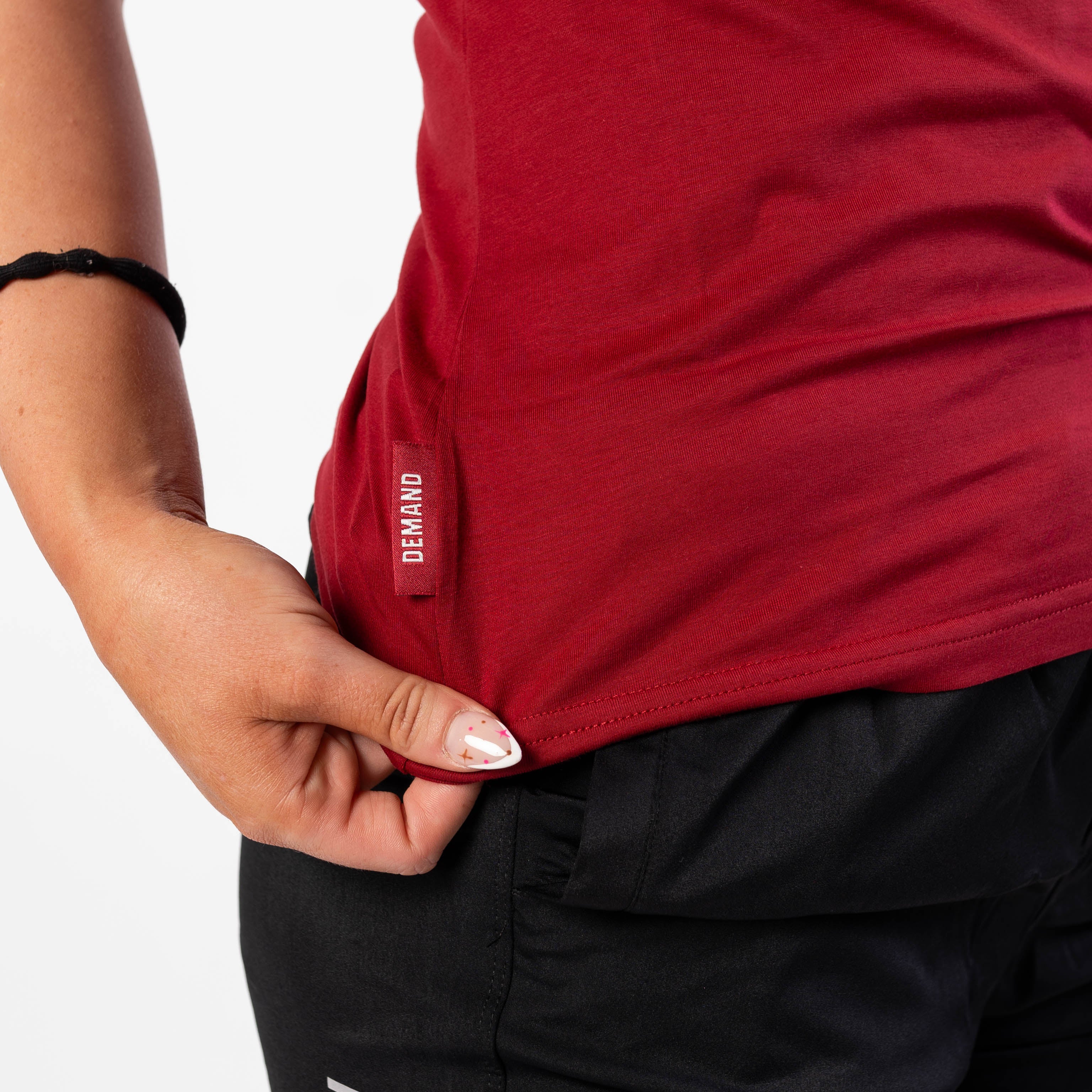 Side Hem Tag on Women's Meet Shirt with Demand Greatness text on the hem tag