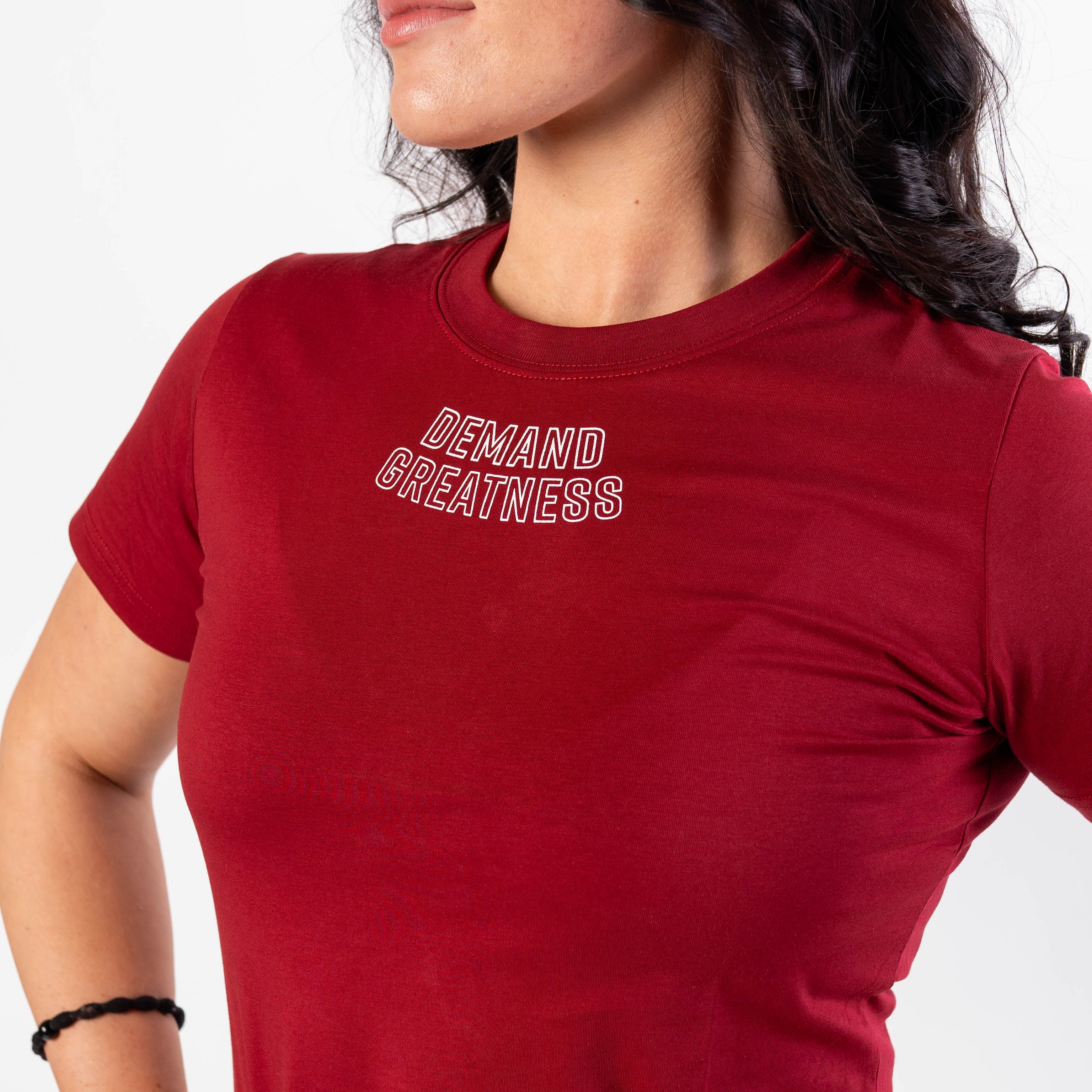 Close up of DEMAND GREATNESS text on the top of center chest of meet shirt to show underneath singlet